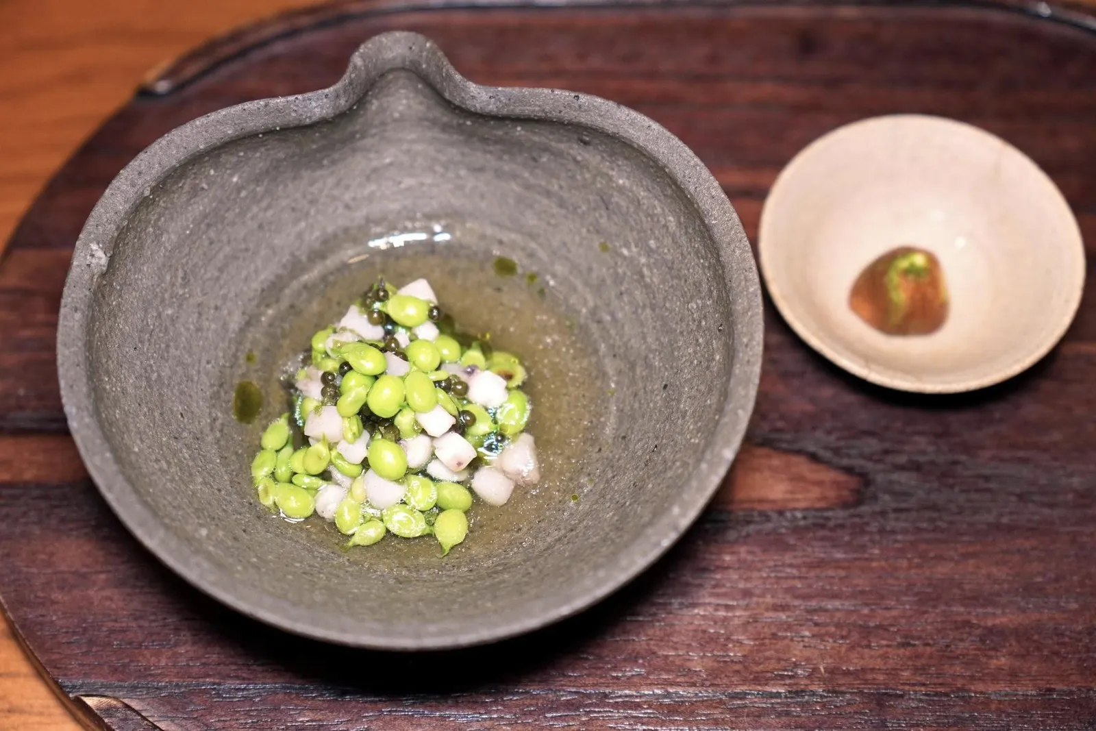 PeasTeardop Peas หรือ Guisante Lágrima เป็นวัตถุดิบสำคัญที่แต่เดิมพบได้ในแถบ Basque Country จนกระทั่งไม่นานมานี้จึงได้มีผู้ริเริ่มนำเมล็ดพันธุ์เข้ามาปลูกที่ประเทศไทย เมล็ดถั่วที่ผ่านการย่างเพื่อให้มีความกรอบเพียงเบา ๆ มีความหวานนำเข้ากันดีกับความเค็มของคาเวียร์คุณภาพดีของประเทศเยอรมันแบรนด์ N25 ซึ่งได้คาเวียร์คุณภาพสูงบ่มนาน 6 เดือนจากฟาร์มในประเทศจีน นอกจากนี้ยังมีความกรอบที่ได้จากหมึกหั่นเต๋าและสาหร่ายพวงองุ่น รอบ ๆ คือซุปใสที่เตรียมมาจากแหนมให้ความหอมอันแสนจะลงตัว เชฟแนะนำให้บีบ Fingerlime Caviar ลงไปช่วยเพิ่มความเปรี้ยวที่พอเหมาะทั้งยังสามารถดึงความหวานของถั่วออกมาให้เด่นชัดมากขึ้นอีกด้วย (17/20)