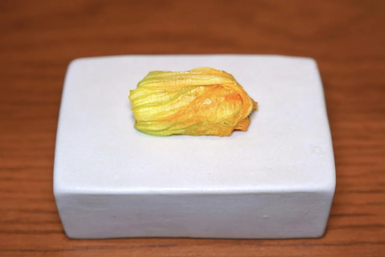 Zucchini Flowerดอกซูคินีที่ห่อหุ้มหน่อไม้ฝรั่งขาวปลูกในประเทศไทย นอกจากนี้ยังมีหมึกดิบช่วยรังสรรค์มิติทางเนื้อสัมผัสที่ลงตัว เชฟเติมแต่งรสชาติด้วยแยมรสเปรี้ยวจากมะยงชิดที่ยังไม่สุกดีอีกด้วย (15/20)