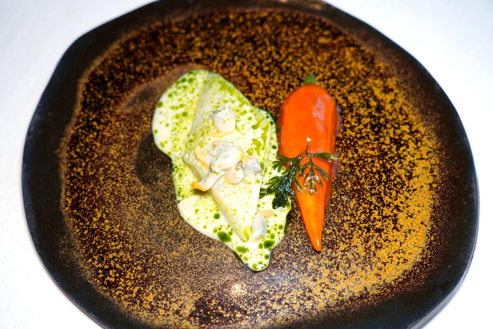 Le sable et la roche Primeur 2024John Dory "à la nacre", Carrot and Cocklesปลา John Dory จากนคร Saint Jean-de-Luz เสิร์ฟมาเป็นชิ้นฟิเลท์ เชฟนำไปผ่ายกระบวนการ Cold Confit กับน้ำมันสมุนไพรแล้วเสิร์หมาในรูปแบบที่เรียกว่า À La Nacre หรือ Mother of Pearl ซึ่งก็คือสีรุ้งที่เกิดขึ้นอย่างสวยงามบนเนื้อปลา ฝั่งขวามือคือแครอทปลอมที่ได้จากการผสมผสาน Purée แครอทเข้ากันกับส้ม จากนั้นนำไปแช่ในน้ำแครอทเพื่อเตรียมรสชาติให้เข้มข้น จากนั้นพนักงานจะเทราดซอสนมที่มีส่วนผสมของสนให้อโรมาเฉพาะตัว ทั้งยังมีหอยลายเคี้ยวหนึบช่วยเพิ่มมิติทางเนื่อสัมผัสและอโรมาของทะเลได้อีกด้วย (18/20)