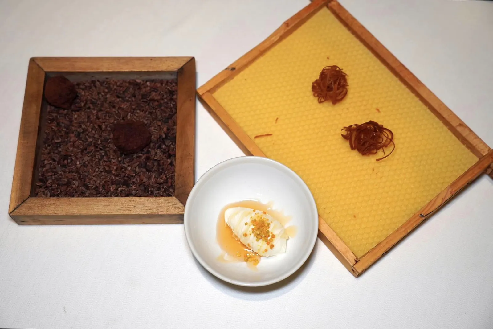 Mignardisesปิดท้ายมื้ออาหารด้วยไอศกรีมขี้ผึ้งราดด้วยน้ำผึ้งของทางร้านและ Honey Vinegar ด้านบนท็อปด้วยเกสรสด ยัง ๆ กันคือบิสกิตน้ำผึ้งกริบ ๆ สำหรับวางลงบนไอศกรีมช่วยเพิ่มมิติความกรอบ สุดท้ายคือช็อกโกแลตบอลเข้มข้น