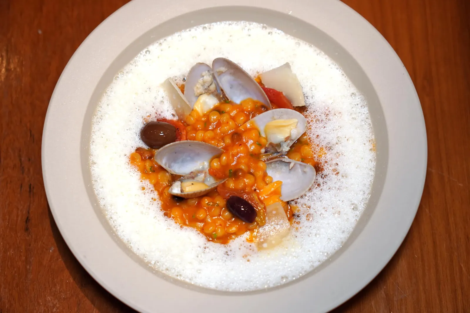 FREGOLA SARDA (550++)Clams, Tomato, Shellfish EmulsionFregola เป็นพาสต้าทรงกลมที่มีต้นกำเนิดมาจากหมู่เกาะ Sardinia เชฟปรุงให้สุกโดยใช้วิธี Risottare หรือการเติมน้ำสต๊อกร้อน ๆ ลงไปในภาชนะที่มีพาสต้าอยู่เรื่อย ๆ จนสุกคล้ายกันกับรีซอตโต้จนได้ Fregola ที่มีเนื้อสัมผัสที่นุ่มหนึบ นอกจากนี้ยังมีองค์ประกอบอื่น ๆ อีกมากมายทั้งหอยลาย มะเขือเทศ มะกอกให้ความเปรี้ยวอุมามิอันแสนกลมกล่อม (14/20)