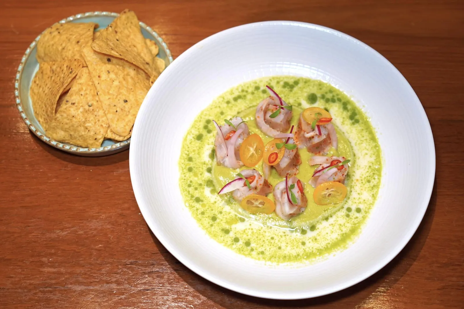 SEA BASS CEVICHE (480++)Avocado, Coriander, Chiliปลากะพงที่ผ่านการดองในน้ำมะนาวให้เนื้อสัมผัสที่ตึงสู้ฟันเบา ๆ ทั้งยังมีส่วนผสมของพริกและผักชีอีกเล็กน้อยช่วยเพิ่มความสดชื่น เชฟจับคู่กับเดรสซิ่งที่เตรียมมาจากกะทิและมะนาว นอกจากนี้ยังมีเนื้อสัมผัสที่หลากหลายของส้มจี๊ด หอมแดง แรดิชฝาน และความกรอบของแผ่นชิปส์ข้าวโพดอีกด้วย (14/20)