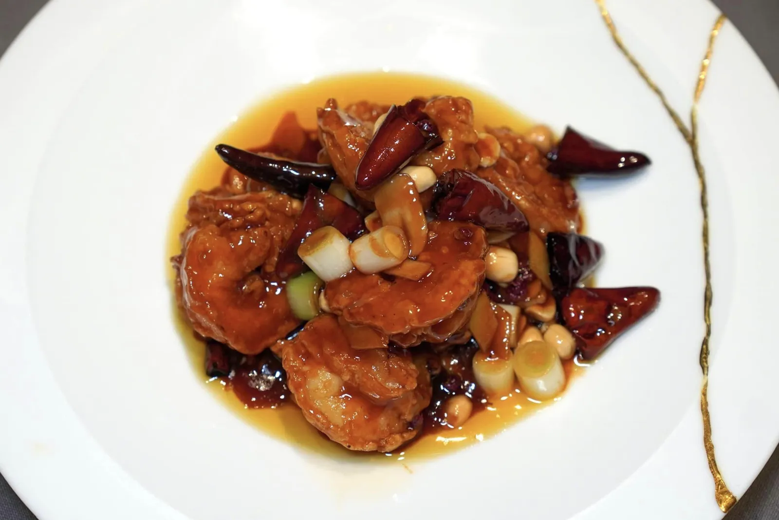 宫保牡丹虾球 (8只) (98 CNY+)”KUNG PAO“ PRAWNSกุ้งชิ้นโตเสิร์ฟมาในสไตล์กงเปา เนื้อกุ้งผัดจนสุกในกระทะร้อนให้เนื้อสัมผัสที่แน่นสู้ฟัน รอบ ๆ ชิ้นกุ้งเคลือบด้วยซอสกงเปารสชาติเข้มข้น (15/20)