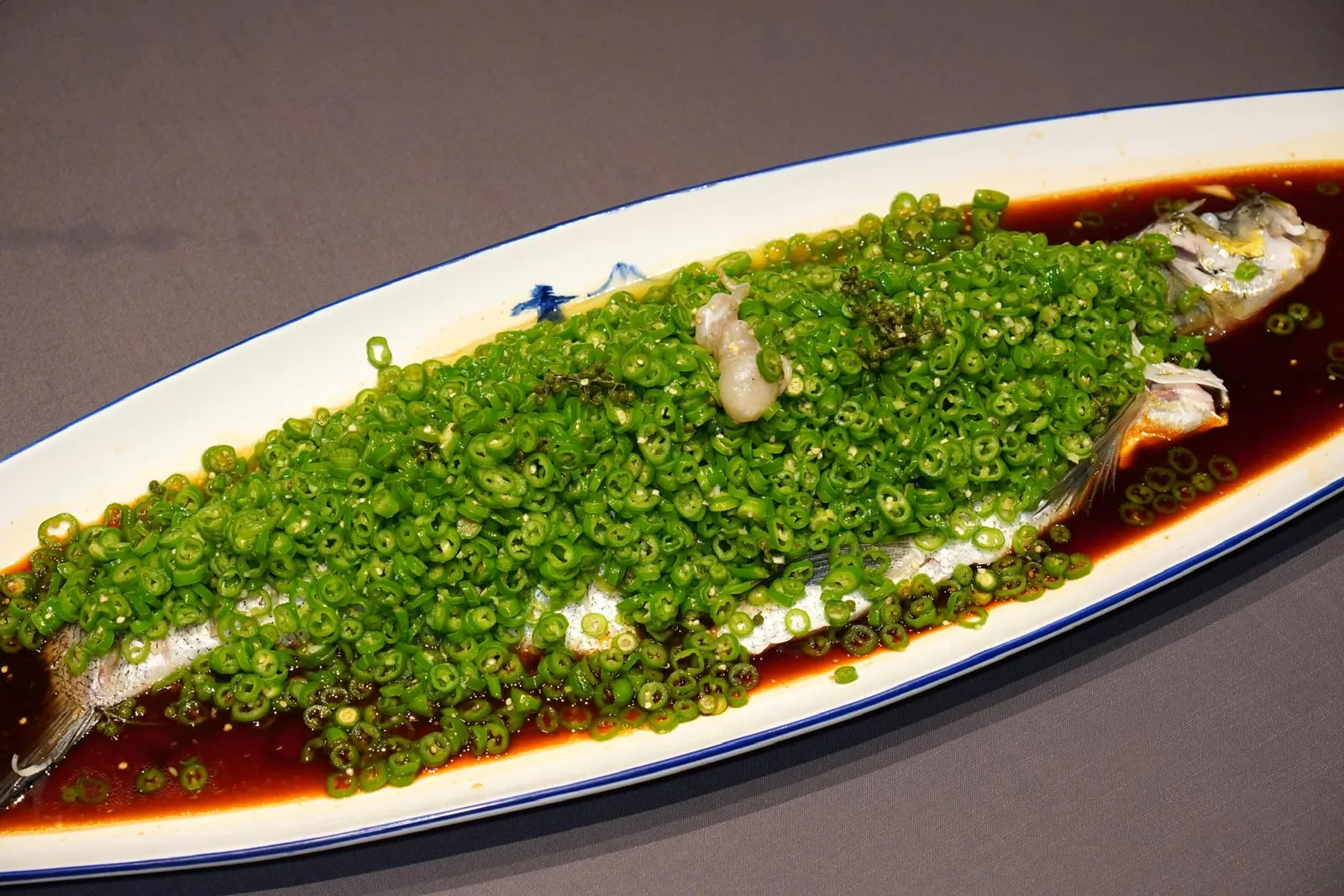 青辣汁水库翘壳鱼 (398 CNY+/Catty)GREEN CHILLI FLAVOUR COCKATOO-WASPFISH水库翘壳鱼 เป็นปลาที่จับได้จากแม่น้ำมีขนาดค่อนข้างใหญ่ประมาณ 4 กิโลกรัม พนักงานเล่าให้ฟังว่าในสมัยก่อนปลาชนิดนี้ขนาดนี้อาจจับได้เพียงปีละ 4 ตัวเท่านั้น เชฟนำปลาว่ายน้ำจากตู้หน้าร้านนึ่งมากับซอสซีอิ๊วสูตรพิเศษให้รสชาติที่กลมกล่อม ด้านบนปรุงรสด้วยพริกเขียวให้กลิ่นฉุนเฉพาะตัวและรสชาติที่เผ็ดจัดจ้าน นอกจากนี้เนื้อปลายังมีความนุ่มละมุนคล้ายคล้ายสำลีอีกด้วย (16/20)