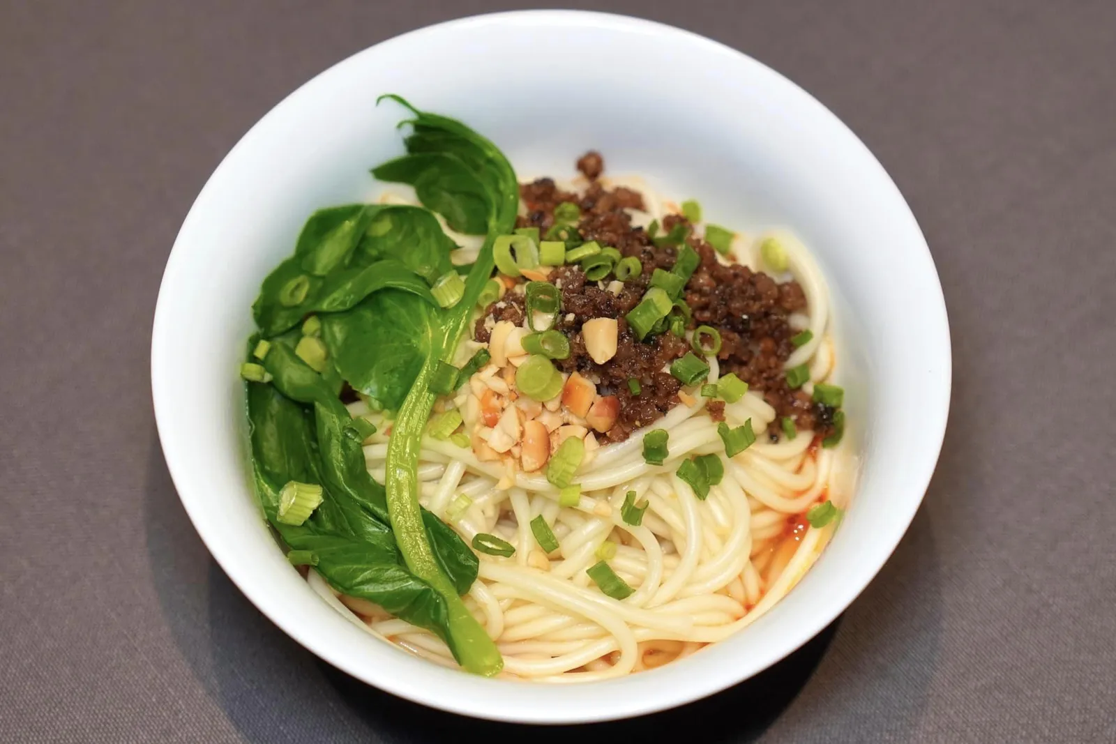 蓉城脆绍抯担面 (18 CNY+)DAN DAN NOODLES WITH PORK TOPPINGบะหมี่ Dan Dan Mian สไตล์เสฉวน เตรียมเนื้อสัมผัสของเส้นออกมาได้ดี อย่าลืมคลุกกันกับซอสรสชาติเข้มข้น มีครบทั้งหอมมันเค็ม ด้านบนด้วยเนื้อหมูสับและถั่วบดช่วยเพิ่มมิติทางเนื้อสัมผัส (15/20)