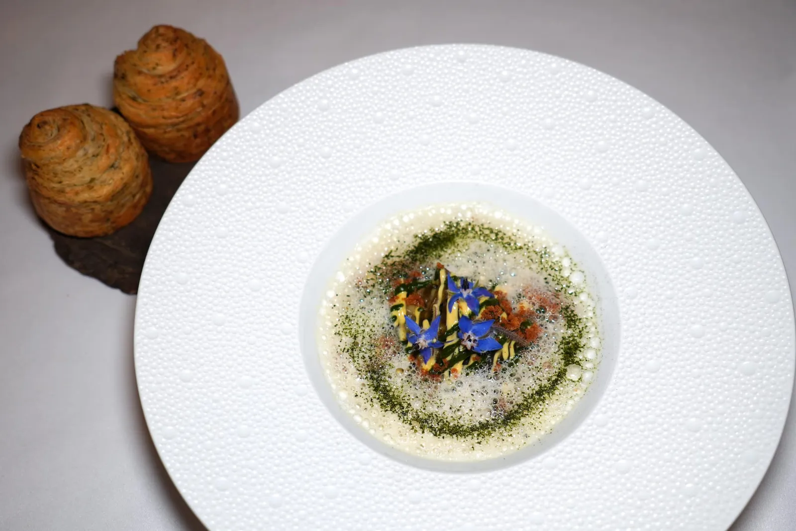 Cockles, seaweed spaghetti, garlic and parsley, beurre blancจานนี้เชฟได้นำสาหร่ายแท้ ๆ เสิร์ฟมาคล้ายกันกับเส้นสปาเก็ตตี้ให้เนื้อสัมผัสที่สู้ฟันคล้ายกันกับความ Al Dente ได้อย่างเหลือเชื่อ กลิ่นเฉพาะตัวของสาหร่ายถูกบาลานซ์ด้วยความหอมของกระเทียมและความเปรี้ยวของ Beurre Blanc ที่เสิร์ฟมาในรูปแบบของ Emulsion นอกจากนี้ยังมีเนื้อสัมผัสที่นุ่มหนึบของหอยลายท้องถิ่นและความเขียวเบา ๆ ของพาสลีย์ ข้าง ๆ กันคือขนมปังสาหร่ายสำหรับรับประทานไปคู่กัน (17/20)