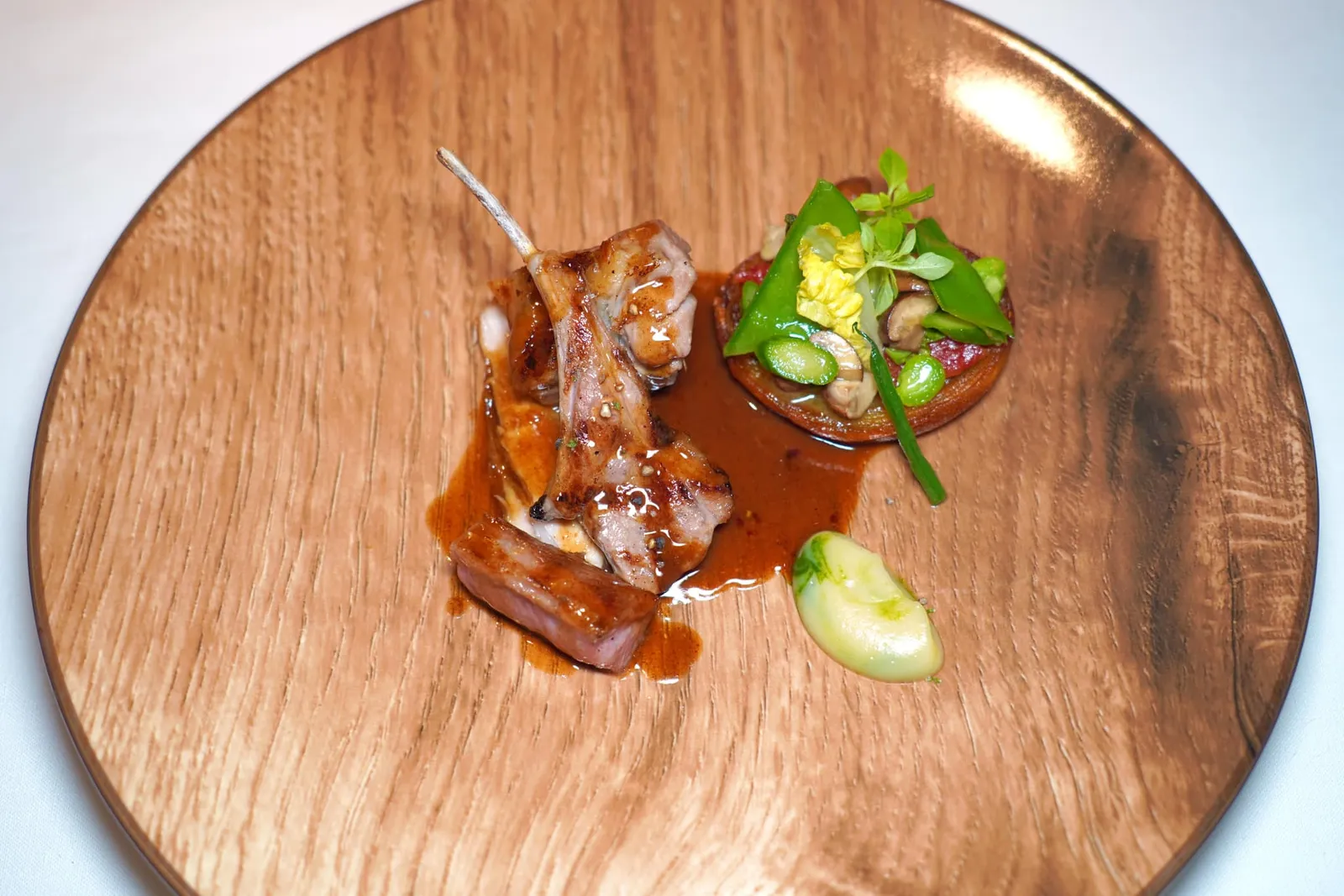 Morceaux choisis d'Agneau de lait des Pyrénées grillé, Petits légumes aux simplesเนื้อลูกแกะยังไม่หย่านมจากแถบเทือกเขา Pyrénées ทางทิศตะวันตกเฉียงใต้ของประเทศฝรั่งเศสย่างมาสุกกำลังดีแล้วเสิร์ฟมา 3 ส่วนจับคู่กับ Purée กระเทียม ข้าง ๆ กันคือมันฝรั่งท็อปด้วยผักจิ๋วหลายชนิดเช่นหัวหอมใหญ่ทอด ถั่วเห็ด เป็นต้น จากนั้นจึงราดด้วยซอสเพื่อเพิ่มคสามเข้มข้น (17/20)