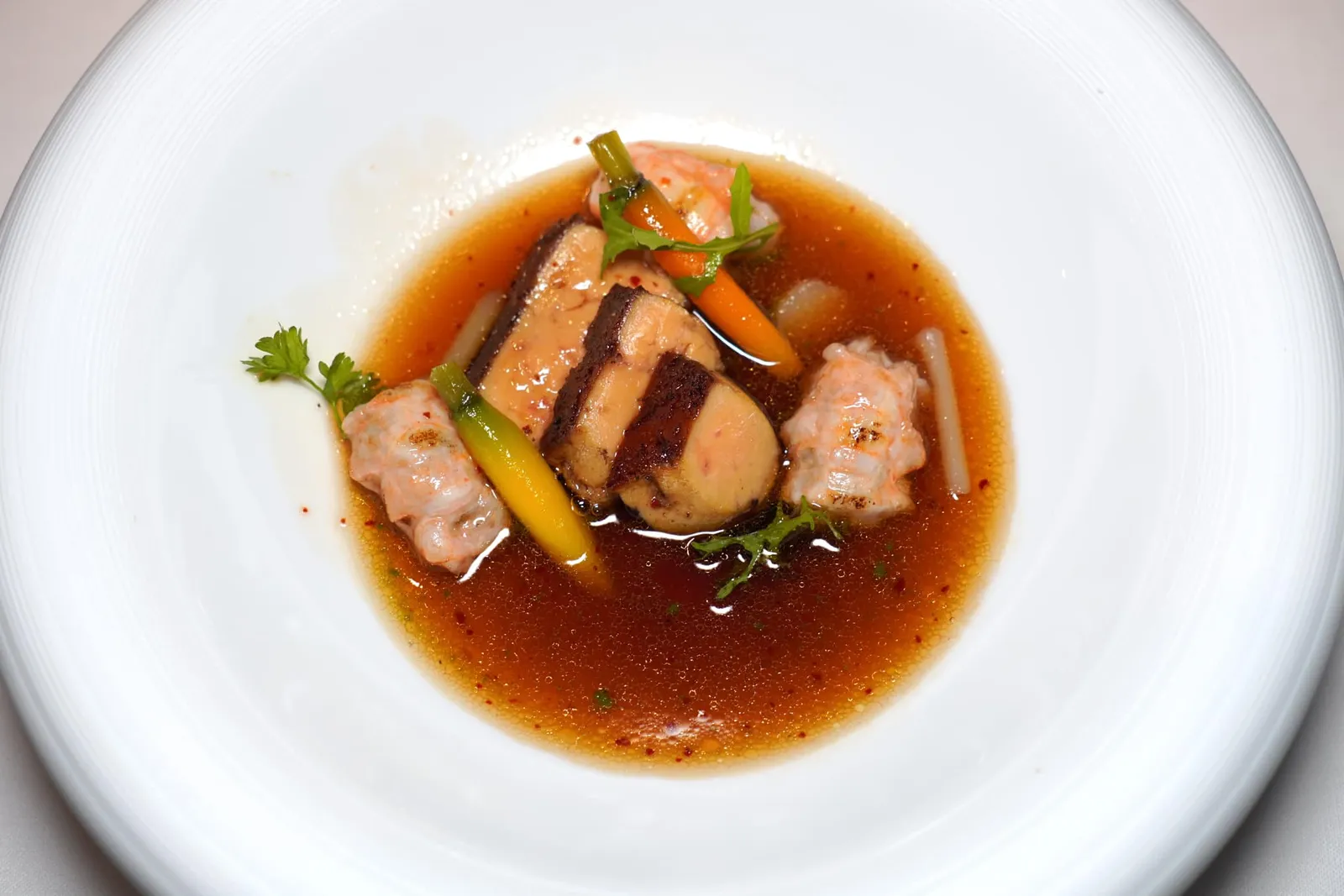 Langoustines “petit doigt” & foie gras sur les braises, Consommé de canard au sésameกุ้งล็องกูสทีนชิ้นจิ๋วที่เชฟเปรียบเปรยว่าลักษณะเหมือนกับนิ้วก้อยนำไปผ่านการย่างเพียงไม่กี่วินาทีในเตาฟืนจนให้เนื้อสัมผัสที่นุ่มละลายและรสชาติที่หวานโดดเด่น ข้าง ๆ กันคือฟัวกราส์ที่จี่มาสุกกำลังดีในกระทะเหล็กหล่อ ยังมีผักจากสวนอีกเล็กน้อย สุดท้ายคือซุปใส Consommé ที่เตรียมมาจากเป็ด น้ำมันงา และซีอิ๊ว (19/20)