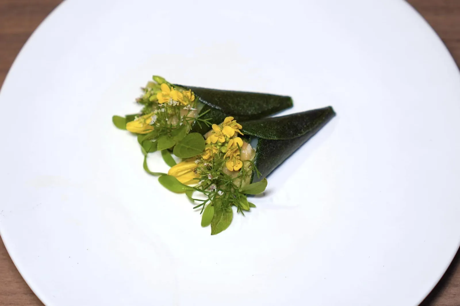 Cod - Aromatic Herbs, Lime, Basilเมนูลุยสวนปลาค็อดที่เชฟนำเนื้อปลาค็อดไปคลุกกับน้ำยำ ด้านนอกคือแผ่นชิปส์ผักรวมห่อล้มช่อดอกไม้เอาไว้อย่างสวยงาม (14/20)