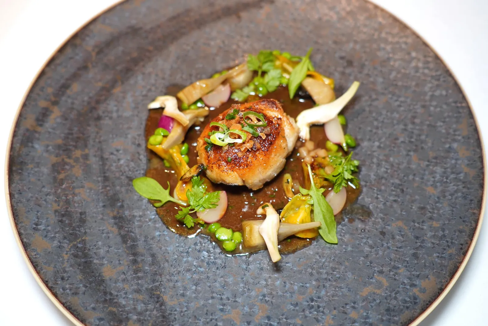 Ris de veau doré au sautoir, Jus “suret” d'échalote confiteSweetbreads หรือสวนต่อมไร้ท่อของลูกบัวจี่มาในกระทะเหล็กหล่อจนสุกกำลังดีสังเกตได้จากสีผิวเหลืองทองสวยงามและเนื้อสัมผัสตรงกลางที่นุ่มละมุน รอบ ๆ คือผักที่ขึ้นในฤดูใบไม้ผลิเช่นอาร์ติโชค ถั่ว และอื่น ๆ เชฟจัยคู่มากับซอสหอมแดงผัดรสชาติออกเค็มกลมกล่อม (19/20)