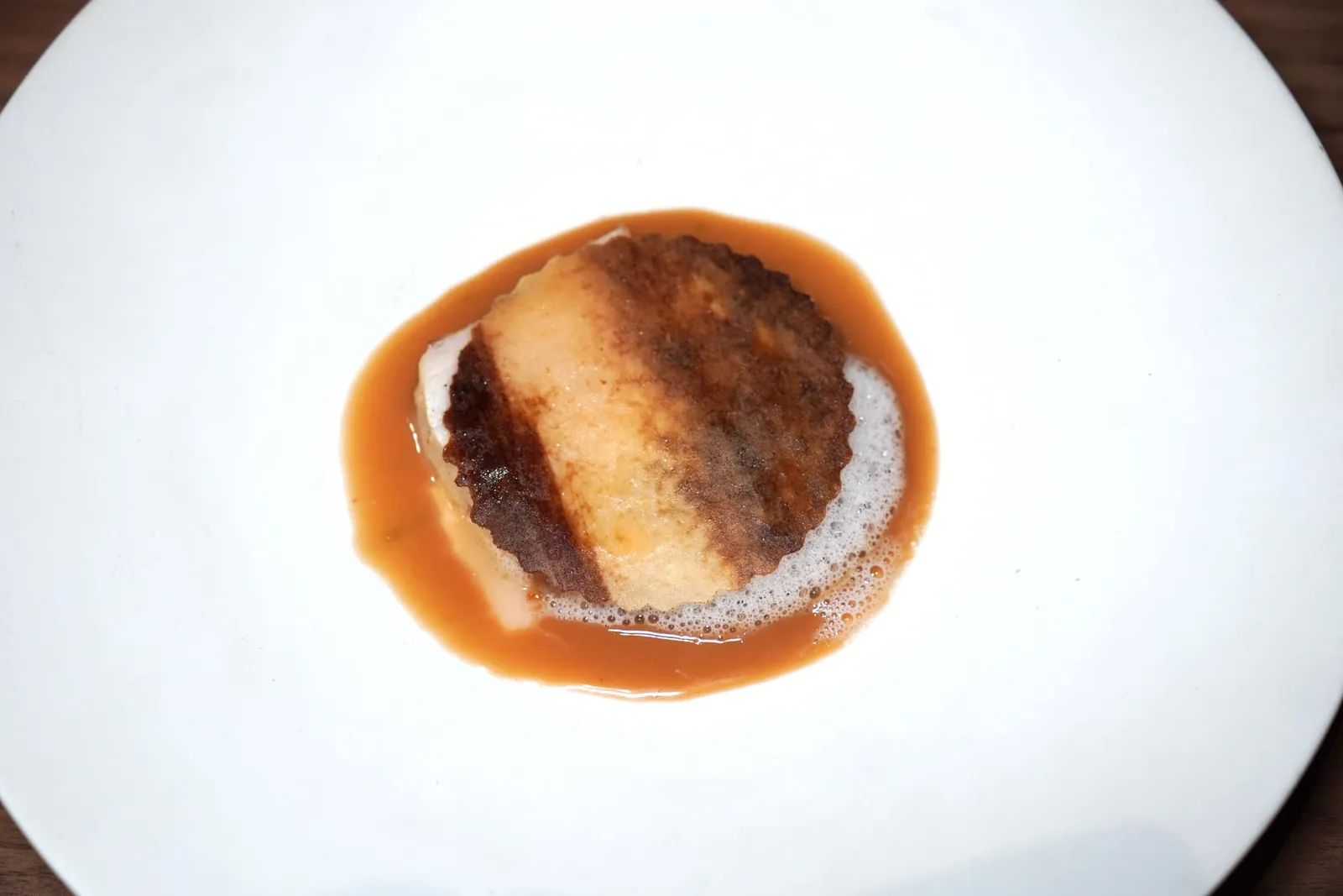 Abura Bozu - Ankimo, Shallot, Coconutปลาต้มกะทิที่ได้จากการนำปลา Abura Bozu จากประเทศญี่ปุ่นเสิร์ฟมากับยอดมะพร้าวย่างให้เนื้อสัมผัสที่สู้ฟันตัดกันกับชิ้นปลา เราสามารถสัมผัสได้ถึงความเปรี้ยวที่ของเลมอนที่เชฟได้มาจากจังหวัดเพชรบูรณ์ ยังมีความครีมมี่หอมมันของอังกิโมะหรือตัยปลาอังเกย ด้านบนคือโฟมกะทิและแผ่นชิปส์กรอบที่เตรียมมาจากหอมแดง รอบ ๆ คือซอสที่ได้จากการนำหัวกะทิไปเคี่ยวกับกะปิและตะลิงปลิงให้ความอุมามิและเปรี้ยวได้อย่างมีมิติ (15/20)