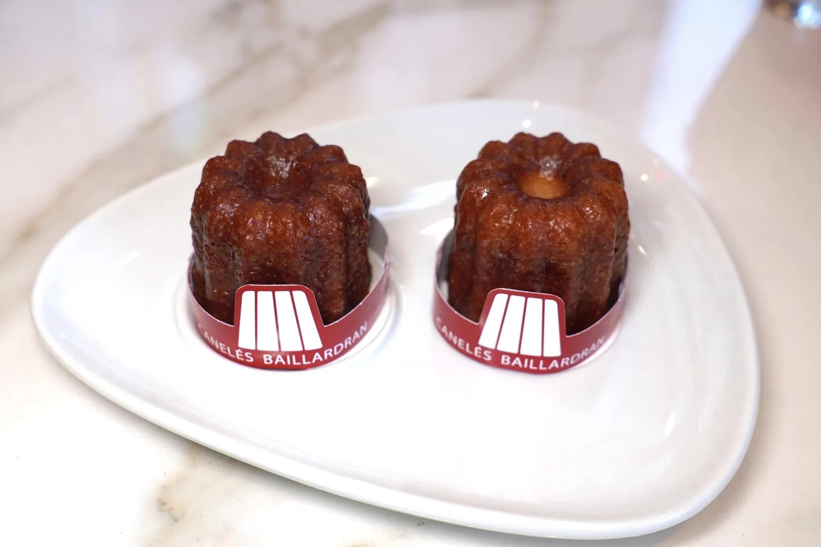 Le Canelés Classique (3.1 €)เมนูดั้งเดิมคือ Canelés สูตรคลาสสิคที่มีเนื้อสัมผัสหนึบที่ขั้นนอก ส่วนตรงกลางยังคงนุ่มอยู่ เนื้อสัมผัสโดยรวมถือว่าดีปานกลาง รสชาติมีความเข้มข้นและมีอโรมาเฉพาะตัวของเหบ้ารัมเด่นชัด (12/20)