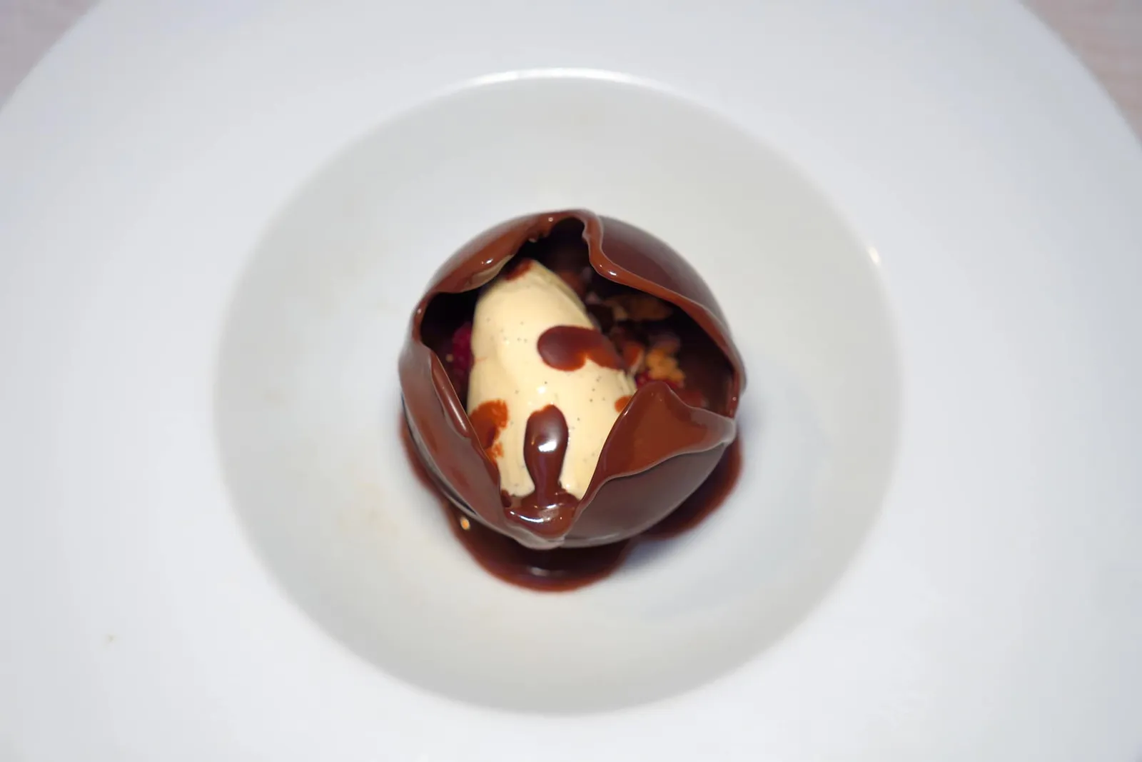 Sphère chocolat, crémeux framboise, gelée citronelle, streusel amande, glace vanille, sauce chocolat caraïbeจากนั้นพนักงานจะเทซอสช็อกโกแลต Caribbean ร้อน ๆ ลงไปเผยให้เห็นภายในที่บรรจุครีมราสเบอร์รี่, เจลลี่ตะไคร้, Struesel อัลมอนด์ และไอศกรีมวานิลลา เมื่อตักชิมจะพบรสชาติอันหลากหลายไม่ว่าจะเป็นความเปรี้ยวของราสเบอร์รี่, ความขมของช็อกโกแลตไปจนถึงความหอมของวานิลลา นอกจากนี้ในจานยังมีอุณหภูมิทั้งร้อนและเย็นอีกด้วย (16/20)