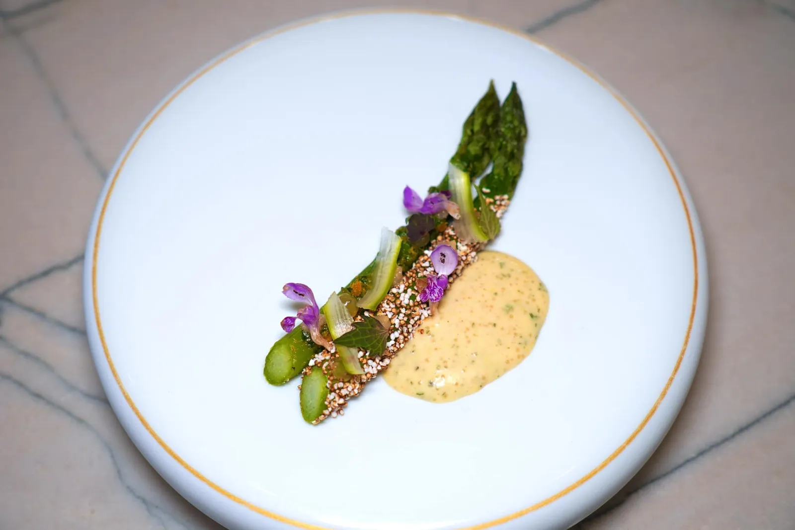 "VOLTAIRE" GREEN ASPARAGUSBerry grown amaranth, lamuim, bottargaคอร์สแรกอย่างเป็นทางการในวันนี้คือหน่อไม้ฝรั่งสายพันธุ์ Voltaire ที่มีรสหวานและไม่มีความขมที่มากเกินไป เนื้อสัมผัสมีความกรอบที่พอเหมาะแต่กลับไร้ซึ่งความกระด้าง เชฟเพิ่มมิติทางเนื้อสัมผัสด้วยการใส่ Amaranth มาล้อมรอบที่พื้นผิวด้านนอก ระหว่างชิมเราจะสัมผัสได้ถึงความหอมของ Hazelnut Paste ยังมีองค์ประกอบของ Lamium (Red Deadnettle) มองเห็นเป็นใบและดอกไม้สีม่วงท็อปอยู่ด้านบน จากนั้นพนักงานจะเทราดซอส Mayonnaise ที่มี Bottarga หรือไข่ของปลาจากลุ่มแม่น้ำ Loire อยู่ลงไปข้าง ๆ สร้างความเปรี้ยวและมันตัดกันกับรสชาติอื่น ๆ ได้อย่างลงตัว (19/20)