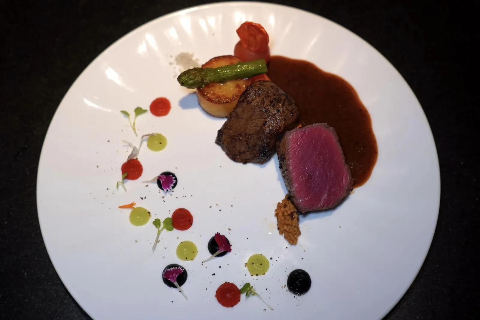 TENDERLOIN (500++)7 Days Dry Aged Tenderloin | Potato Fondant | Sauté Vegetables | Beef Jusเมนคอร์สจานแรกคือเนื้อวัวไทยวากิวจากจังหวัดสกลนคร เชฟนำไป Dry Aged นาน 7 วันก่อนจะย่างแล้วพักเนื้อถึง 3 ครั้ง จากนั้นจี่บริเวณผิวจนกรอบโดยที่เนื้อตรงกลางยังคงไว้ซึ่งความฉ่ำได้ รอบ ๆ คือผักกงฟีที่ผัดกับเนยจนหอม ยังมีมันฝรั่งฟองดองต์ที่ผ่านการตุ๋นมานาน 6 ชั่วโมง สุดท้ายเชฟได้ทำการหยดเจลพริกแดง กระเทียมชาโคล และวาซาบิลงไปด้วย (13/20)