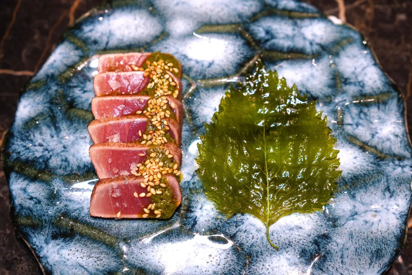 Tuna Tataki With Mojo VerdeJapanese Maguro Tataki with Spanish green sauce “Mojo Verde”ปลาทูน่าจากประเทศญี่ปุ่นที่บ่มกับน้ำแข็งประมาณ 1 อาทิตย์ จากนั้นเซียบริเวณผิวเพื่อเสิร์ฟมาในสไตล์ Tataki จากนั้นเสิร์ฟมากับซอส Green Mojo ที่มีต้นกำเนิดมาจากแถบหมู่เกาะ Canart Islands ของประเทศสเปน แต่เชฟกลับเลือกใช้องค์ประกอบที่ให้ความเปรี้ยวจากฝั่งญี่ปุ่นเช่นยูซุแทนสูตรดั้งเดิม ข้าง ๆ กันคือใบชิโสะทอดเสิร์ฟให้รับประทานคู่กัน (13/20)