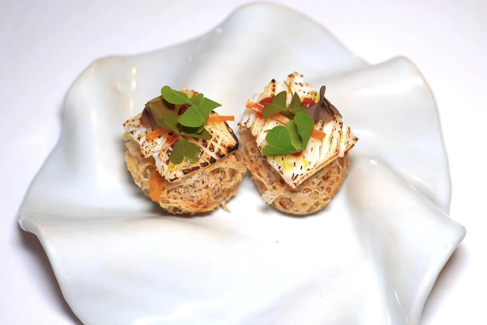 🥄 AMUSE-BOUCHEติ่มซำอย่างเผือกทอดที่เชฟบิ๊กทดลองทำซ้ำหลายครั้งจนได้เนื้อสัมผัสและความฟูกรอบที่หาใครเทียบเคียงได้ยาก จากนั้นท็อปด้วยครีมกระเทียมต้น ชิ้นหมึกย่างถ่าน พริกเหลืองดอง และ Oxalis (15/20)