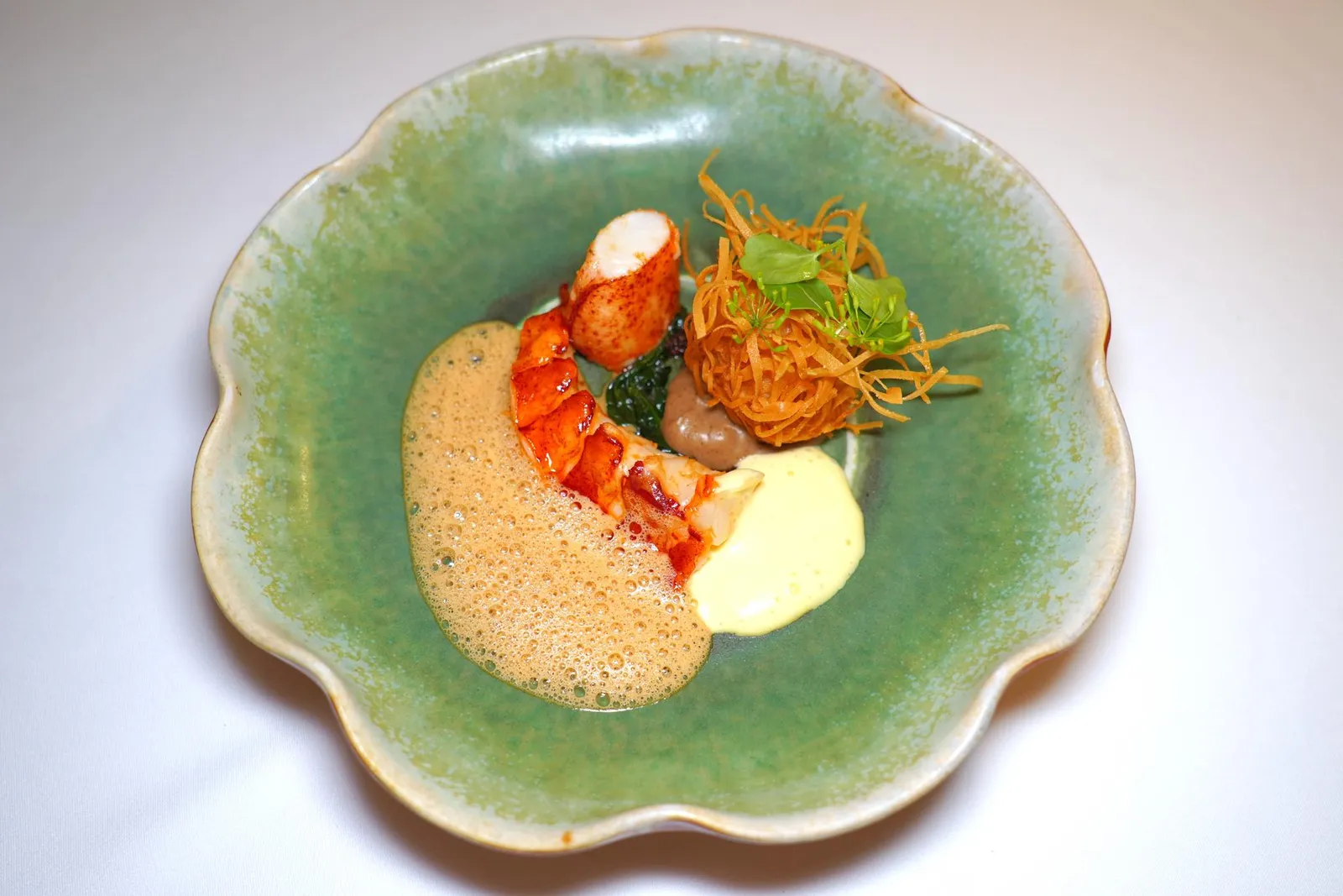 🥄 ENTREEBinchotan Lobster Tail | Deep Fry Claw Balls | XO Sauce | Shitake Puree | Spinach | Bisque | Ginger Hollandaiseส่วนหางของกุ้งล็อบสเตอร์ย่างบนถ่าน Binchotan จนได้ความสุกที่พอเหมาะ เชฟเสิร์ฟมากับก้ามกุ้งหวาน ๆ ส่วนหัวถูกนำไปเตรียมเป็น Lobster Bisque เสิร์ฟมาในรูปแบบของโฟมทำให้รสชาติไม่หนักจนเกินไป ข้าง ๆ คือลูกชิ้นทอดที่เตรียมมาจากข้อกุ้งให้ความเด้งที่ดีงามไร้ที่ติ เพียวเรเห็ดชิทาเกะและซอส XO ช่วยเสริมความเค็มและมันให้กับจาน จากนั้นพนักงานจะตีก Hollandaise ที่ใส่อโรมาของขิงเบา ๆ ลงไปช่วยเสริมอโรมาได้อย่างมีมิติ (15/20)