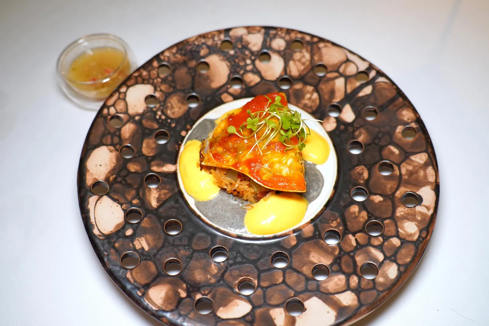 🥄 MAINCrab Roe Rice | Black Pepper | Nahmjim Seafoodส่วนโปรตีนหลักของคอร์สคือปูทะเลไข่จากจังหวัดสมุทรสาครที่ผ่านการแกะเปลือกก่อนจะสะดุ้งกับเกลือเล็กน้อยแล้วใส่กลับเข้าไปในหม้อข้าว ซอสสีเหลืองในจานคือ Hollandaise ที่ใส่อโรมาของพริกแกงและจิ๊กโฉ่ว ซอสสีดำคือ Beurre Blanc ที่ใส่อโรมาของพริกไทยดำเอาไว้ ข้าง ๆ กันคือน้ำจิ้มซีฟู้ดที่มีกลิ่นเฉพาะตัวของเต้าหู้ยี้มาช่วยบาลานซ์ตัดเลี่ยนนั่นเอง (16/20)