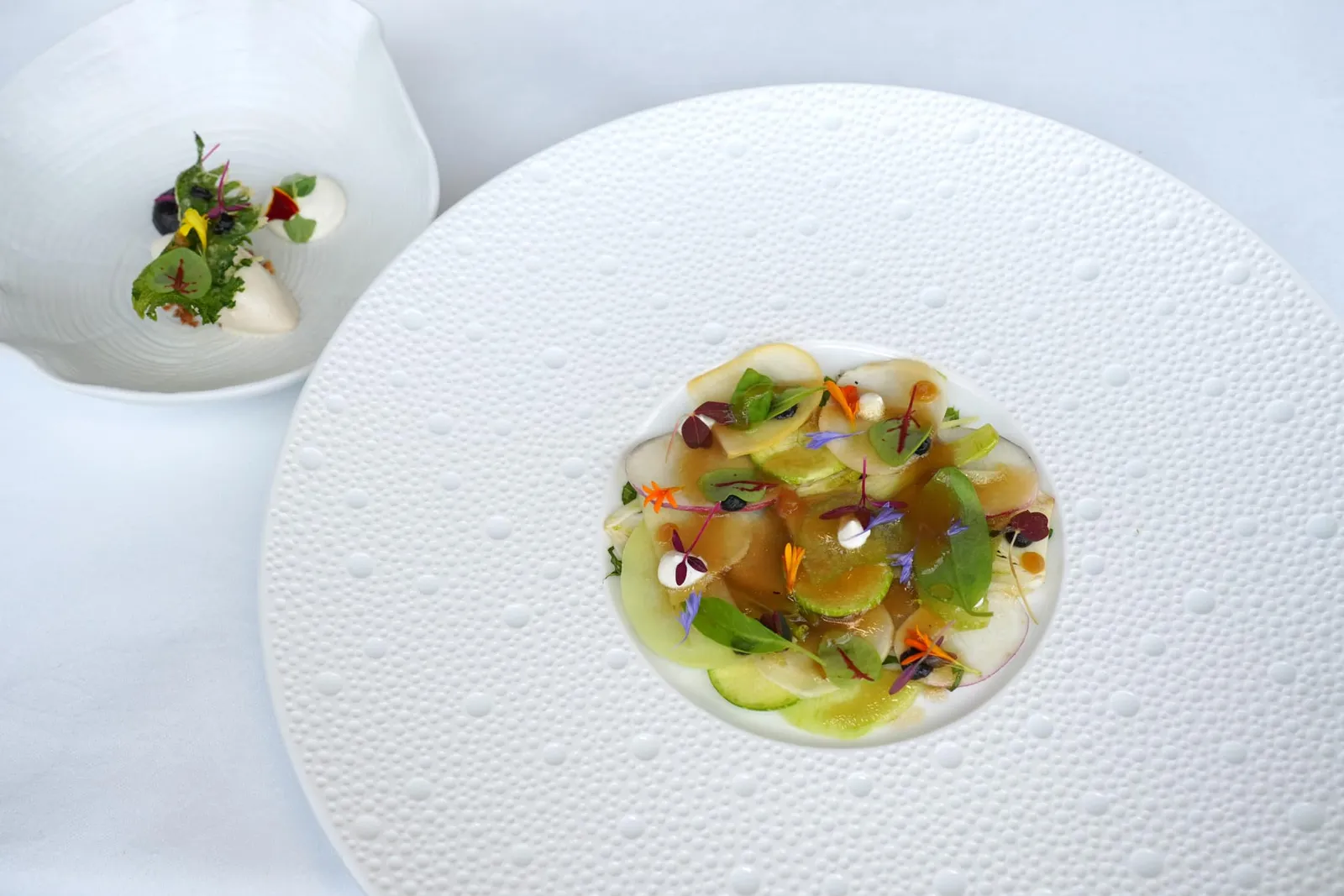 Garden carpaccioFresh sorrel / yoghurt / almond / black garlic / oxalysคอร์สแรกเชฟนำเสนอสลัดผักต่าง ๆ ตามฤดูกาลจากสวนเช่นซอเรล ซูคินี่ และเฟนเนลโดยเชฟแล่บาง ๆ มาในรูปแบบของ Carpaccio สำหรับน้ำ Dressing เชฟเตรียมมาจากน้ำผึ้งและใบ Thyme ยังมีองค์ประกอบในถ้วยข้าง ๆ คือไอศครีมถั่วอัลมอนด์และองค์ประกอบของกระเทียมดำ นอกจากนี้ยังมี Oxalis หรือใบชิโสะใส่มาเพื่อเพิ่มกลิ่นเฉพาะตัว (16/20)