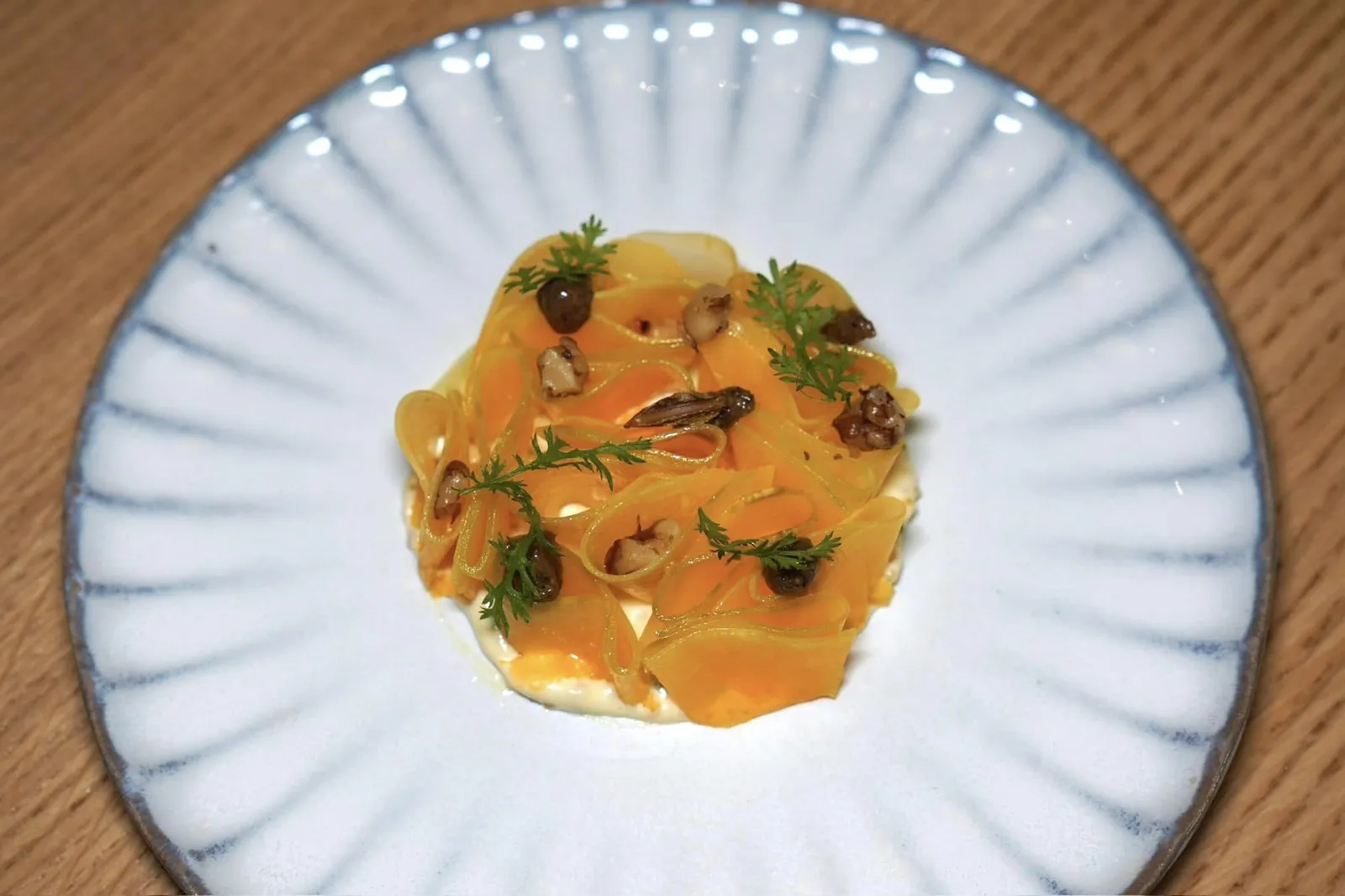 🥄 Inspirations végétales et légumineusesCourge Hopi imprégnée d'une huile de noix Franquette, sauce tartare légère. ”Bocerno“Hopi เป็นพืชตระกูลสควอชท้องถิ่นที่มีสีส้มโดดเด่น เชฟหมักในน้ำมันถั่ววอลนัทฟรังก์เกตต์ก่อนจะฝานเป็นชิ้นบาง ๆ แล้วเสิร์ฟมาเพื่อให้มีเนื้อสัมผัส Al Dente หรือสู้ฟันคล้ายกันกับเส้นพาสต้า ด้านบนคือถั่ววอลนัทฟรังก์เกตต์เสิร์ฟมาแบบปกติและอีกบางส่วนที่ย่างและหมักในมิโสะ ด้านล่างรองด้วย Tartare Sauce ที่เตรียมมาจากไข่ปลาให้ความรู้สึกที่ไม่หนักท้องจนเกินไป (17/20)