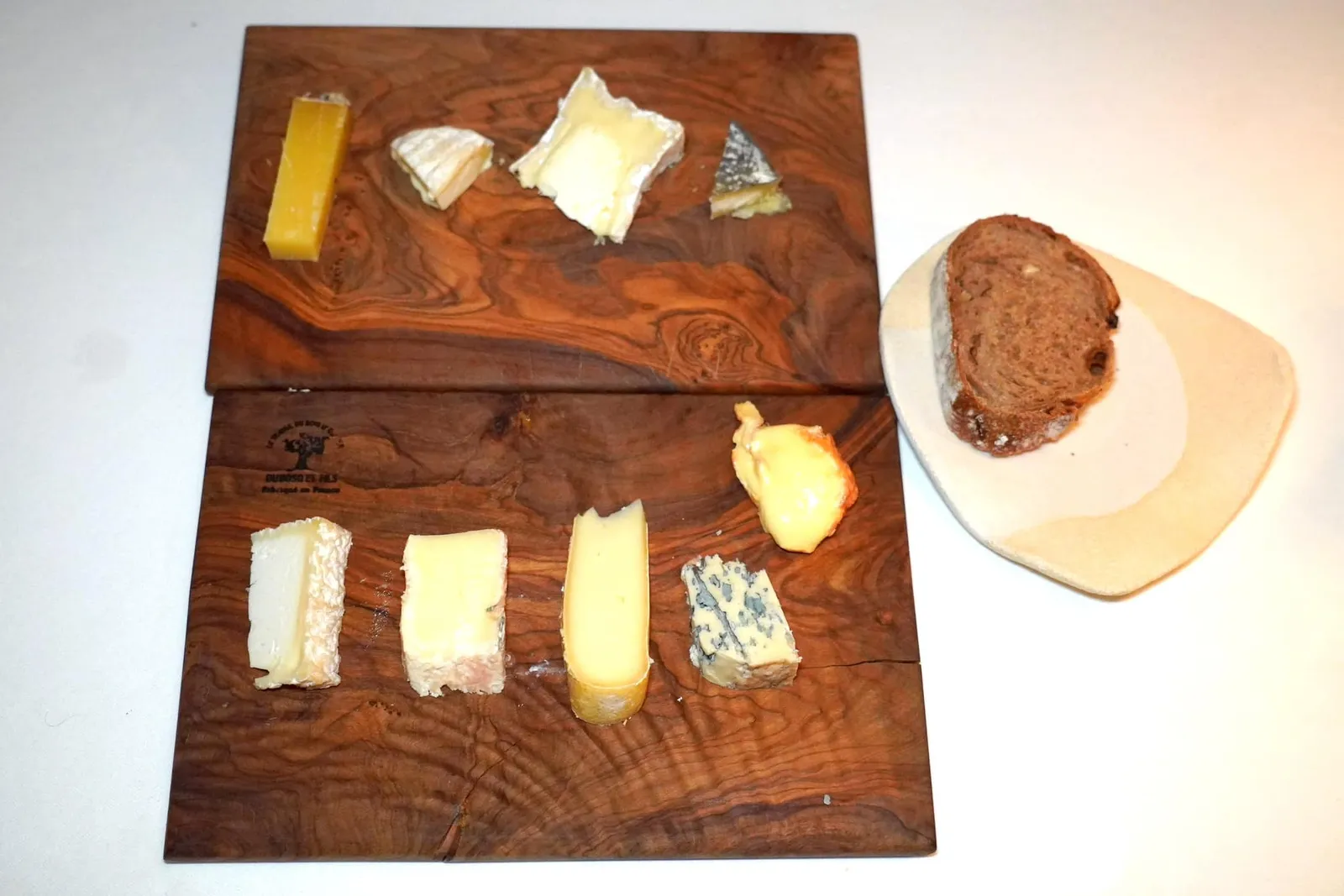 Cheesesfresh and agedพนักงานจะตัดแบ่งเป็นชิ้นแล้วเสิร์ฟมาบนจานไม้คู่กับขนมปัง Fruit Bread