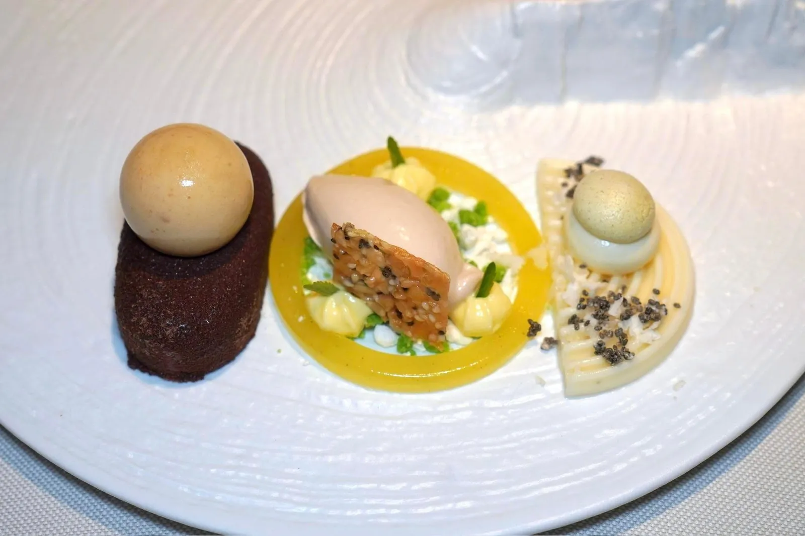 Chestnutstorrone • chocolate • cauliflower • steviaองค์ประกอบแรกในจานฝั่งขวามือคือมูสไวท์ช็อกโกแลตจับคู่มากับองค์ประกอบของกะหล่ำดอก จากนั้นท็อปด้วย Yuzu Drop อยู่ด้านบนสุด ถัดมาคือไอศกรีมเกาลัดและแผ่น Torrone กรอบสร้างมิติทางเนื้อสัมผัสที่ดีจับคู่มากับวงแหวนของ Cooked Apple รสเปรี้ยว สุดท้ายคือครีมเกาลัดให้รสหวานตัดกันกับความเปรี้ยวของเบอร์รี่แดง ด้านบนคือพราลีนเกาลัด นอกจากนี้ยังมี Popling Candy สร้างความสนุกในปากได้ขณะรับประทานอีกด้วย (17/20)