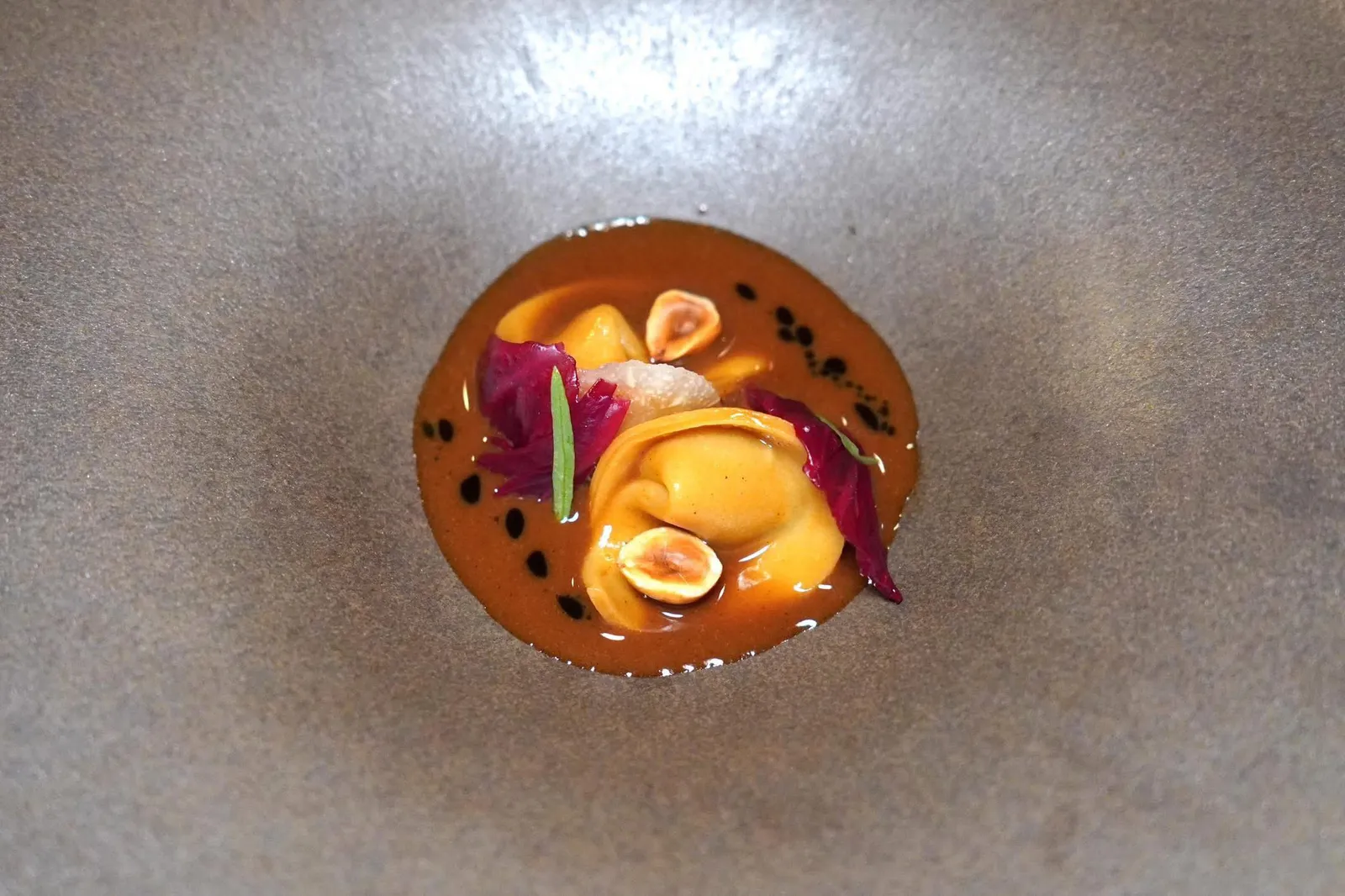 Cappelletti, black pear, sunchokeพาสต้าจานที่สองคือ Cappelletti โฮมเมดทรงเกี๊ยว ด้านในสอดไส้แก่นตะวันและ Pituralka ซึ่งเป็นสายพันธุ์ของลูกแพร์ท้องถิ่นของประเทศสโลวีเนียให้รสชาติหวานอันมีมิติ รอบ ๆ คือซอสเนื้อที่ผ่านการเคี่ยวจนได้รสชาติเข้มข้นตัดด้วยความฉุนของน้ำมันทาร์รากอนและความกรอบของถั่วฮาเซลนัท ด้านบนท็อปด้วยผัก Radicchio และทาร์รากอน (19/20)
