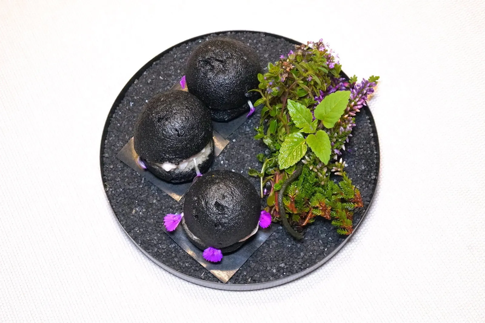 Black brioche bread with smoked pike-perch and clove blossomsLiquid cheese gnocchi and hawk wing mushroomขนมปัง Brioche ที่มีสีดำจากดีหมึกทอดจนกรอบ ด้านในคือปลา Pike Perch รมควัน ตกแต่งด้วยกลีบดอก Clove และอโรมาหอม ๆ ของ Aromatic Herbs จากสวนของทางร้าน (19/20)