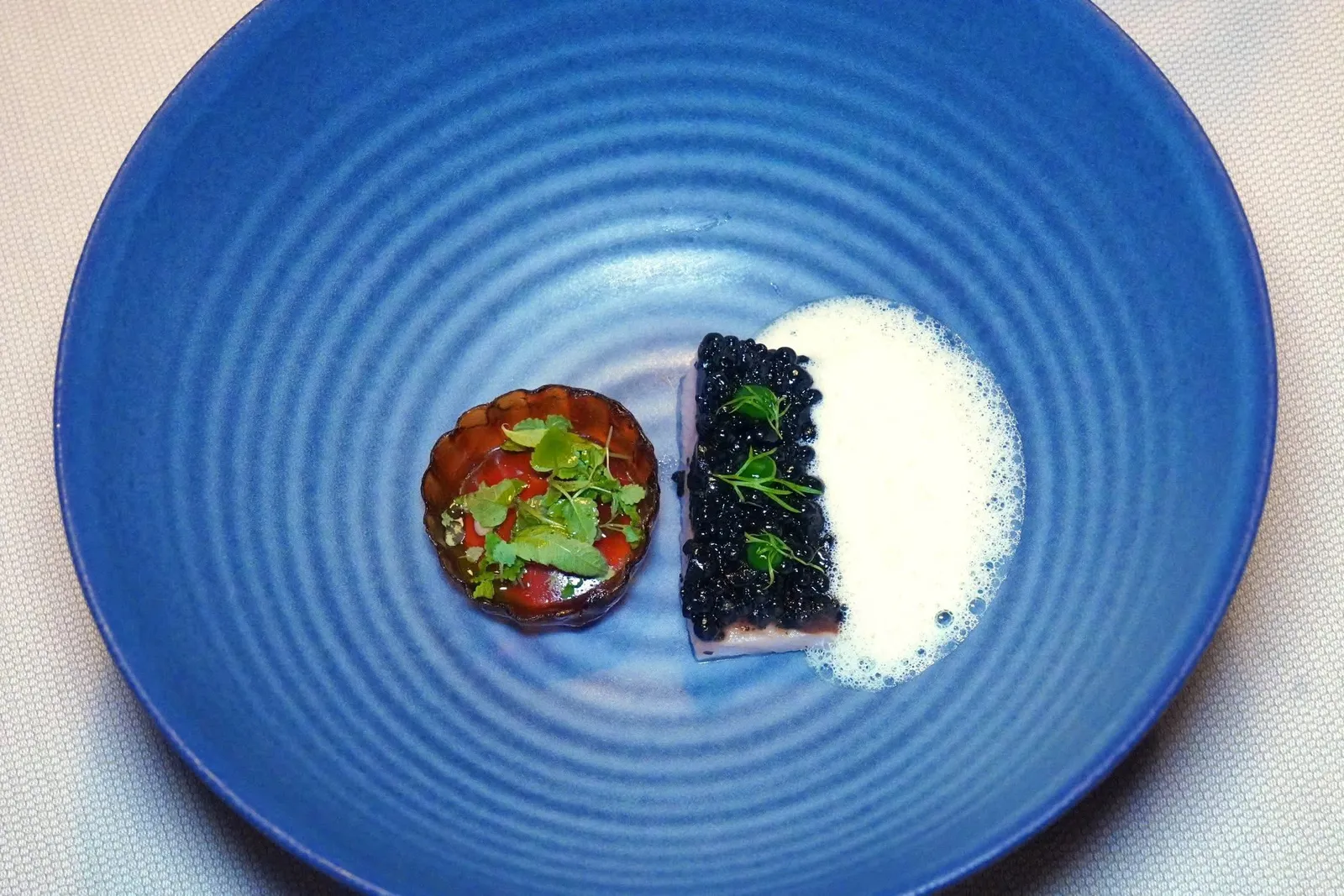 Brooke trout with black pearls and mustard garlic oiljellied tartelette of wild herbsปลา Brooke Trout ปรุงให้สุกด้วยอุณหภูมิที่ไม่สูงนักเพื่อคงไว้ซึ่งความฉ่ำของเนื้อปลา ด้านบนคือไข่มุกสีดำที่เตรียมมาจาก Vegetable Ash หรือเถ้าของผักเสิร์ฟมาคู่กันกับ Aromatic Herbs JGel สีเขียวและเฟลเนลสด ข้าง ๆ กันโฟมสีขาวที่เตรียมมาจาก Burnt Butter หรือเนยไหม้ สุดท้ายคือ Tartelette เสิร์ฟมาเป็นเจลลี่ที่มีส่วนผสมของเครื่องเทศ ด้านในบรรจุสลัดสมุนไพรจากสวนของทางร้านคลุกเคล้าไปกับน้ำมัน Pimpinelle (18/20)