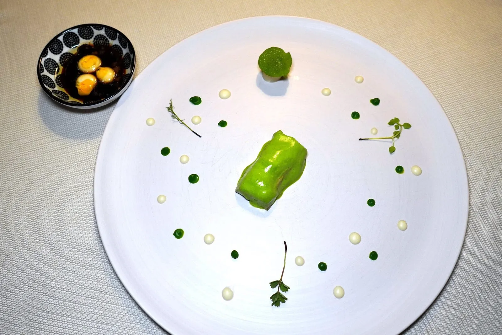 Veal with grass foamcelery root and liquid onion gnocchiเนื้อลูกวัวที่ผ่านการหมักแล้วปรุงให้สุกในอุณหภูมิที่ไม่สูงนักเพื่อคงไว้ซึ่งความฉ่ำของเนื้อ เชฟล้อมรอบเนื้อด้วยโฟมหญ้า Wheat Grass สีเขียวสดให้ความครีมมี่และละมุน เชฟเสิร์ฟมากับรากของเซเลอรี่ พูเรสีขาวเตรียมมาจาก White Onion ส่วนเจลสีเขียวเตรียมมาจาก Aromatic Herbs ในจานด้านบนคือใบ Camomile ด้านล่างคือใบ Pimpinelle ยังมีใบ Chickweed ใส่มาให้ด้วย สุดท้ายคือ Demi-glace ที่ได้จากการเคี่ยวลูกวัวกับเครื่องเทศจนงวดให้รสชาติที่เข้มข้น ไฮไลท์คือ Liquid Gnocchi ที่เตรียมมาจาก White Onion และไขกระดูกซึ่งจะแตกระเบิดออกในปากเมื่อแรกเคี้ยวนั่นเอง (18/20)