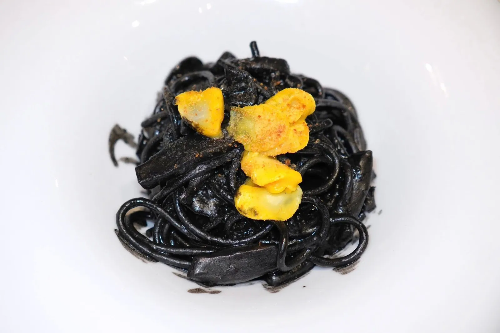 Spaghetti with “Sepe in tecia” - Classic Venetian Cuisine 19th century (28 €)Bronze drawn durum wheat spaghetti with cuttlefish in black sauce and saffron cuttlefish roeเราขอแนะนำเมนูอาหารอิตาลีสไตล์เวนิสสุดคลาสสิกอย่างพาสต้าเส้น Spaghetti คลุกเคล้ามากับดีหมึกเข้มข้นให้กลิ่นที่หอมเฉพาะตัว ในจานยังมีชิ้นหมึกปรุงสุกกำลังดีสร้างความเด้งและกรอบตัดกันกับเนื้อสัมผัส Al Dente ของเส้นพาสต้า ด้านบนคือไข่หมึกเคี้ยวหนึบที่มีสีเหลืองของหญ้าฝรั่น (14/20)