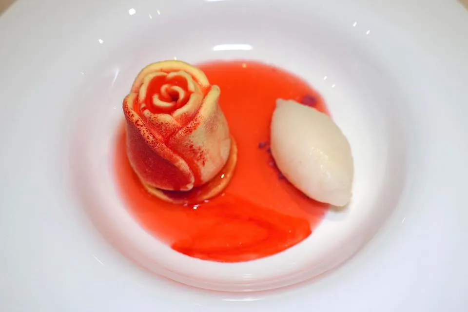 Torta “Biancha Reale” (15 €)Revised recipe by Bartolomeo Scappi, active in Venice and Papal Chef in the 16th century, Ginger cheesecake rose with a lemon cream center on an almond shortbread base, raspberry soil, rose sorbet and rose waterของหวานห้ามพลาดจานที่เชฟหยิบยกมีเมนูของ Bartolomeo Scappi ผู้ซึ่งเคยทำงานเป็นเชฟให้กับสันตะปาปาในช่วงศตวรรษที่ 16 มีลักษณะเป็นชีสเค้กขิงรูปดอกกุหลาบเสิร์ฟมากับเลมอนครีม ด้านล่างคือขนมปังอัลมอนด์กรอบและครัมเบิ้ลราสเบอร์รี่ นอกจากนี้ยังมีซอร์เบท์กุหลาบและน้ำกุหลาบหอม ๆ ใส่มาด้วย (15/20)