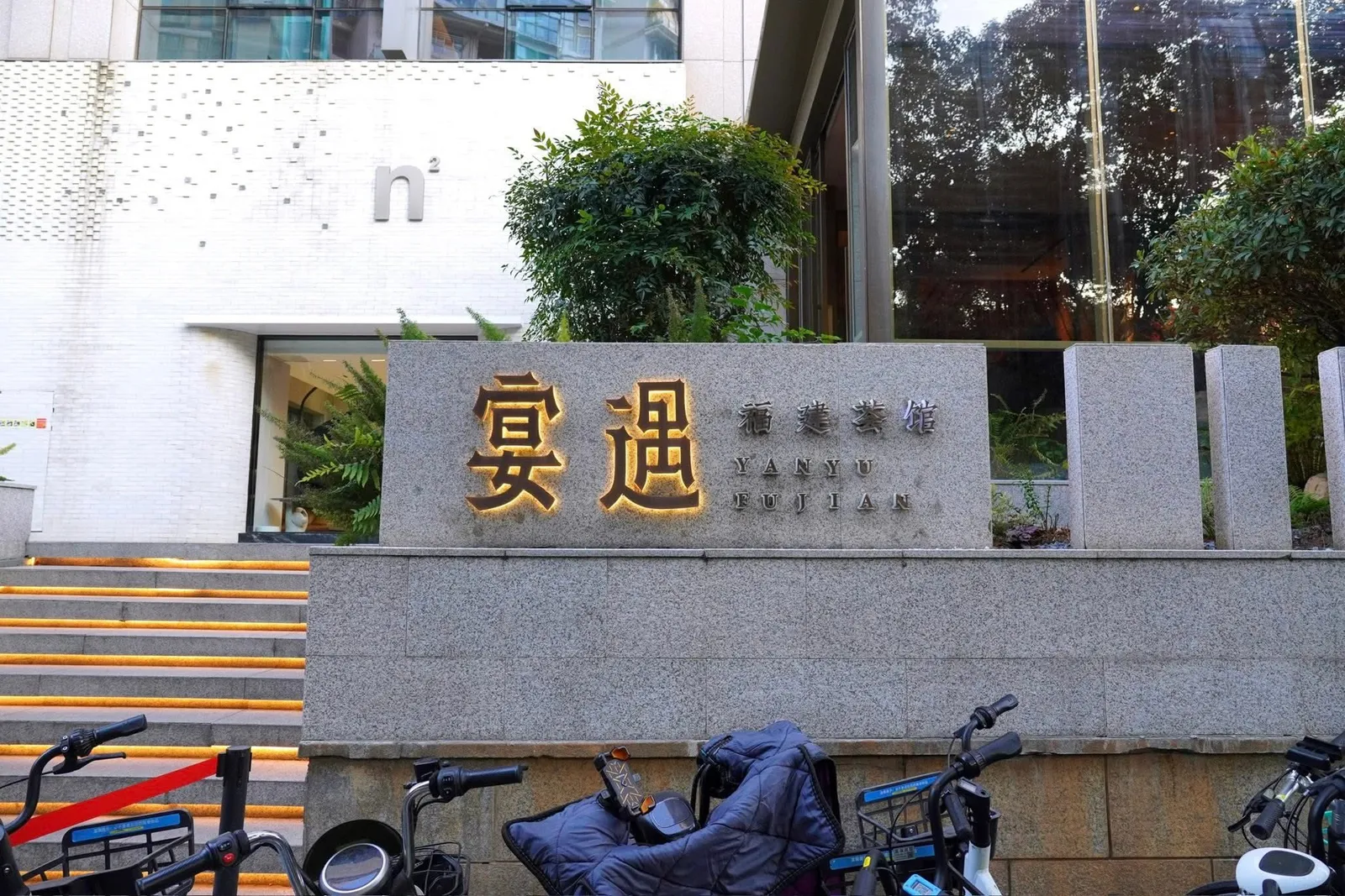 หน้าร้านโดดเด่นด้วยป้ายหินพร้อมกับชื่อร้านเขียนกำกับเอาไว้ว่า 宴遇福建荟館 Yanyu Fujian