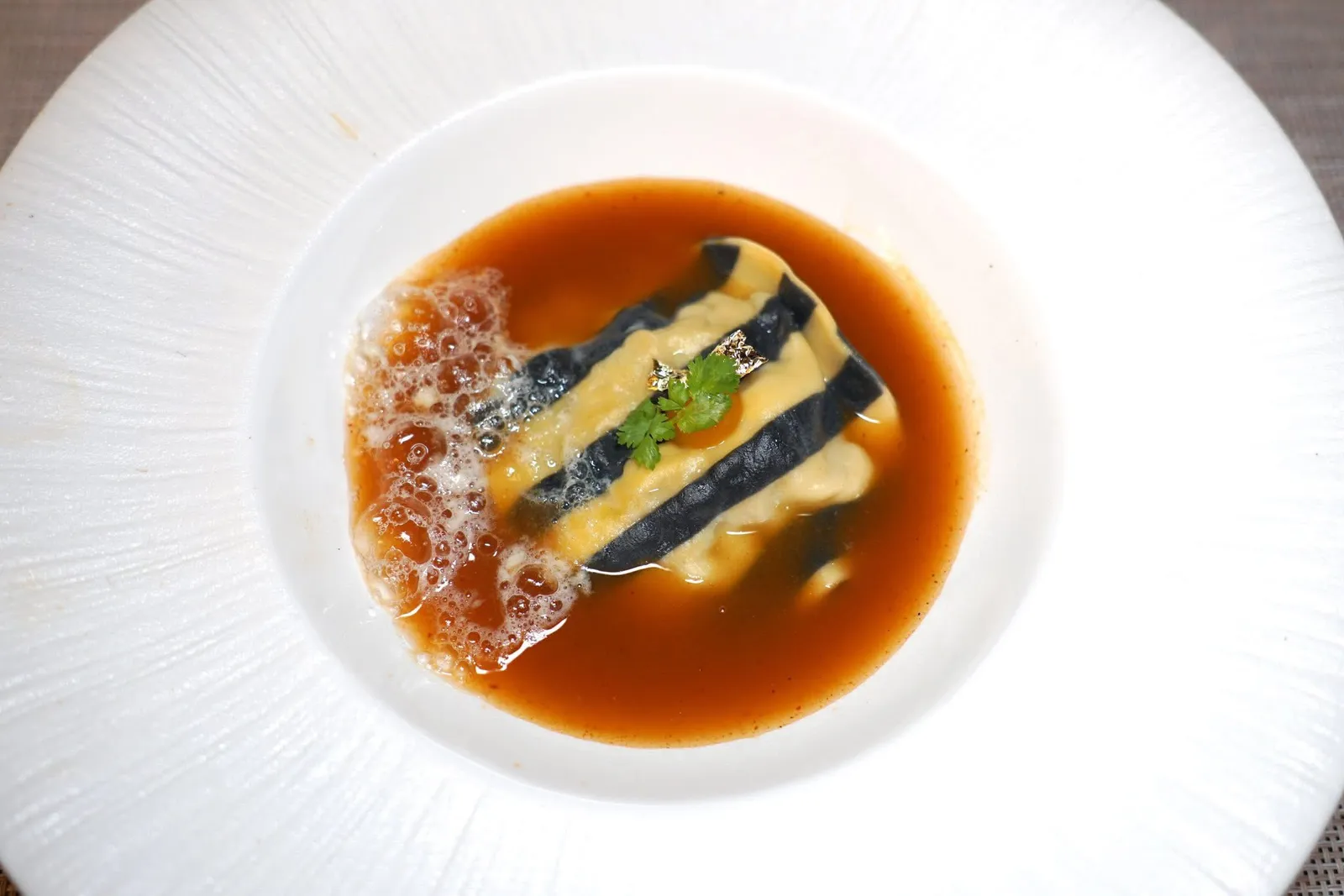 Chapter ThreeIn the OceanSeafood Ravioli with Spicy Soupไฮไลท์ของมื้อนี้เป็นจานที่เราชื่นชอบมาก ๆ นั่นก็คือราวิโอโลชิ้นโต ด้านในประกอบไปด้วยวัตถุดิบจากท้องทะเลหลากหลายอย่างสร้างมิติทางเนื้อสัมผัสที่แตกต่างกัน ด้านบนท็อปด้วยโฟมมะนาว เชฟใช้เทคนิคการเตรียมน้ำซุปแจ่วฮ้อนให้มีรสชาติจัดจ้านและเข้มข้นโดยอาศัยแรงบันดาลใจมาจาก Bouillabaisse ของฝรั่งเศสตอนใต้ (13/20)