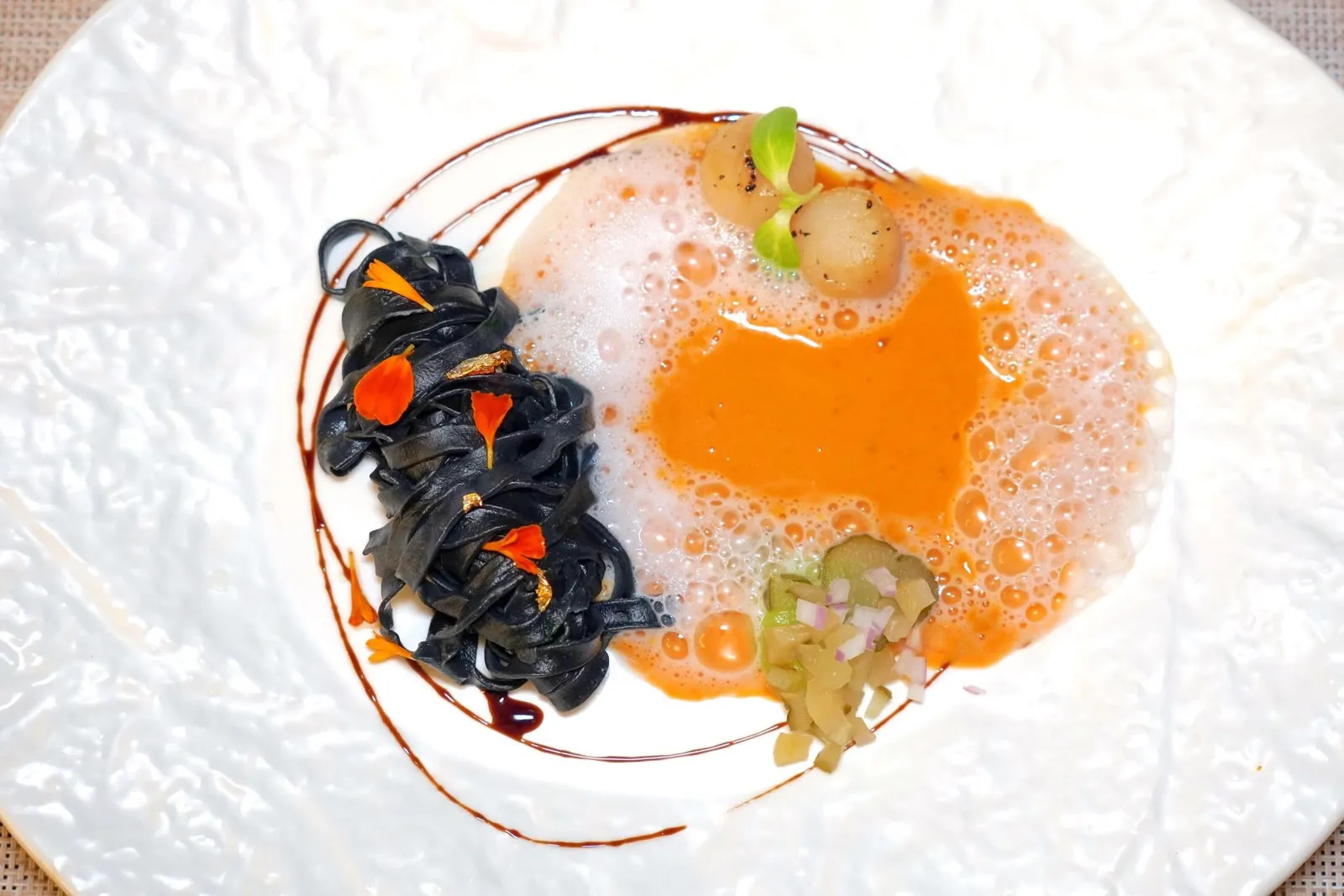 Chapter FourNorthern MistKhao Soi Riceberry with Scallopอีกหนึ่งจานเด็ดประจำมื้อคือข้าวซอยที่เตรียมเส้นมาจากข้าวไรซ์เบอร์รี่จับคู่มากับหอยเชลล์ย่าง ตรงกลางคือซอสข้าวซอยสูตรคนเหนือให้รสชาติจัดจ้านและหอมกลิ่นเครื่องเทศและสมุนไพร ข้าง ๆ กันคือผักดองและเจลผักดองให้ความเปรี้ยวเพียงเบา ๆ (13/20)