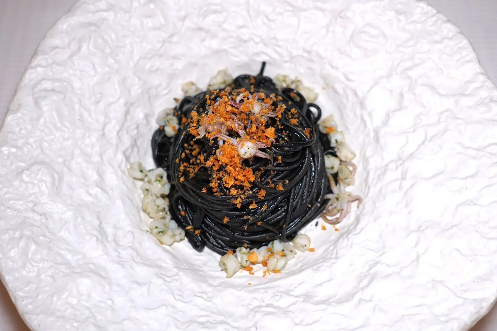 SQUID INK SPAGHETTI (600++)With garlic, extra virgin olive oil, chili, squid and squid inkพาสต้าสปาเก็ตตี้หมึกดำคลุกเคล้ามากับน้ำมันมะกอกเอ็กซ์ตร้าเวอร์จิ้น จากนั้นปรุงรสด้วยพริกให้มีรสชาติจัดจ้านเบา ๆ เชฟใส่ชิ้นหมึกนุ่มหนึบและดีหมึกให้ความหอมโดดเด่น
