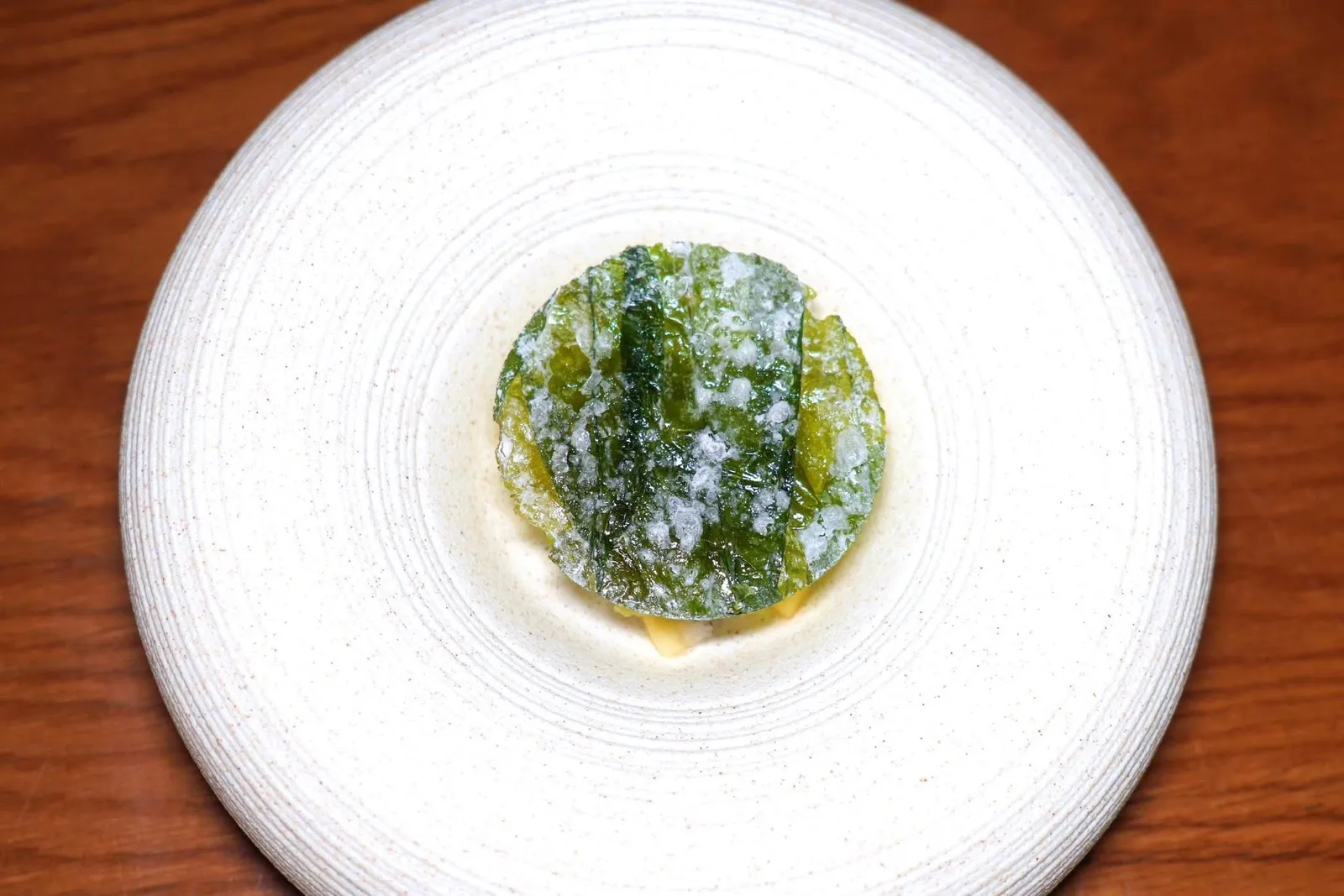 ใบเหลียง & ลูกกาหยีMelinjo Leaf / Cashew Juice / Seasonal Fruits / Cashew Nut Honey Crumbleล้างปากด้วยไอศกรีมใบเหลียงผสมกันกับกาหยี เกลือ และน้ำตาล ด้านบนท็อปด้วยใบเหลียงกรอบ ด้านล่างคือเมล็ดมะม่วงหิมพานต์คลุกกับน้ำผึ้งจากฟาร์มไร่ ณ รักษ์ของจังหวัดภูเก็ตทำเป็นครัมเบิ้ลกรอบ ยังมีผลไม้ตามฤดูกาลคือสับปะรดภูเก็ตและแก้วมังกร สุดท้ายคือว่านหางจระเข้เชื่อมกับน้ำผึ้งช่วยเติมเต็มความสดชื่นได้อย่างน่าประทับใจ (15/20)