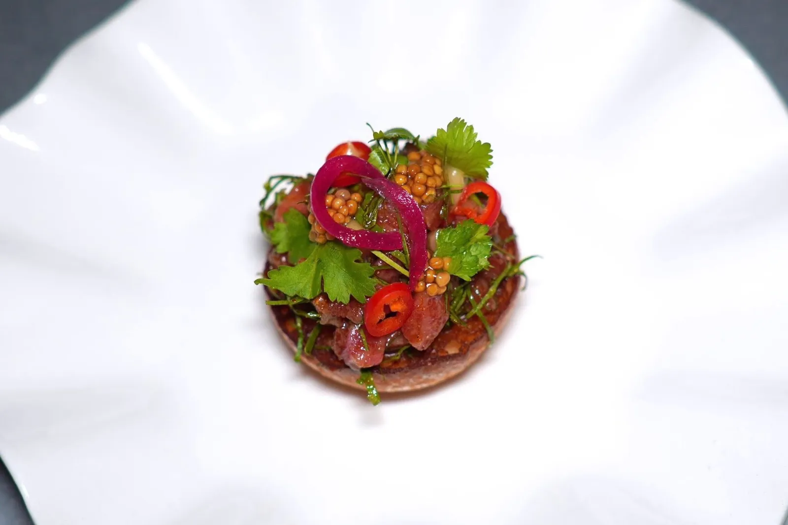 BEEF TARTARE (490++)ก้อยเนื้อได้จากการนำเนื้อวัววากิวสับเป็น Tartare จากนั้นคลุกเคล้ากับซอสน้ำปลาเคี่ยวแล้วปรุงรสแบบลาบ ด้านล่างคือขนมปังนุ่ม ๆ