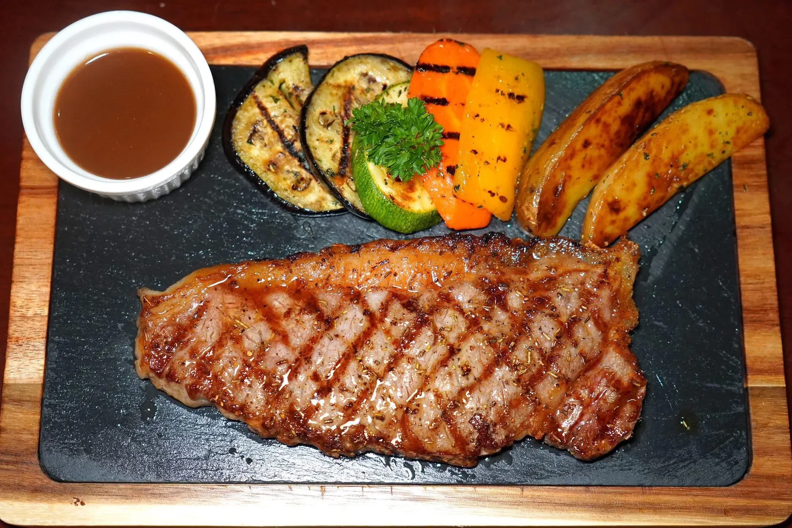 Costata di Manzo (480)Striploin Black Angus Steak (Grain-fed 150 days)สเต๊กเนื้อวัวแบล็คแองกัสชิ้นโตเสิร์ฟมาที่ความสุกมีเดียมแรร์ ข้าง ๆ คือซอสไวน์แดงรสดี (12/20)