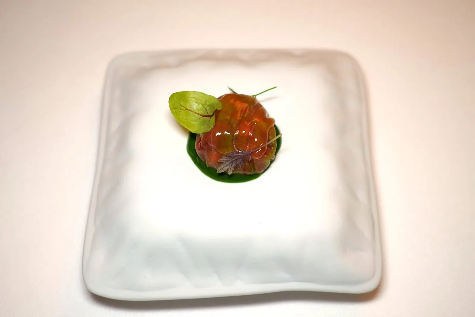 AMUSE-BOUCHEในที่นี้คือเซรามิครูปหมอน ด้านบนคือ Lettuce Bonbon ทรงกลม ด้านในสอดไส้เนื้อลูกวัวที่ผสมผสานถั่วฮาเซลนัทและความหวานเปรี้ยวของสตรอว์เบอร์รี่ป่า รอบ ๆ คือ Bitter Herb Cream สร้างมิติทางรสชาติที่กลมกล่อม (17/20)