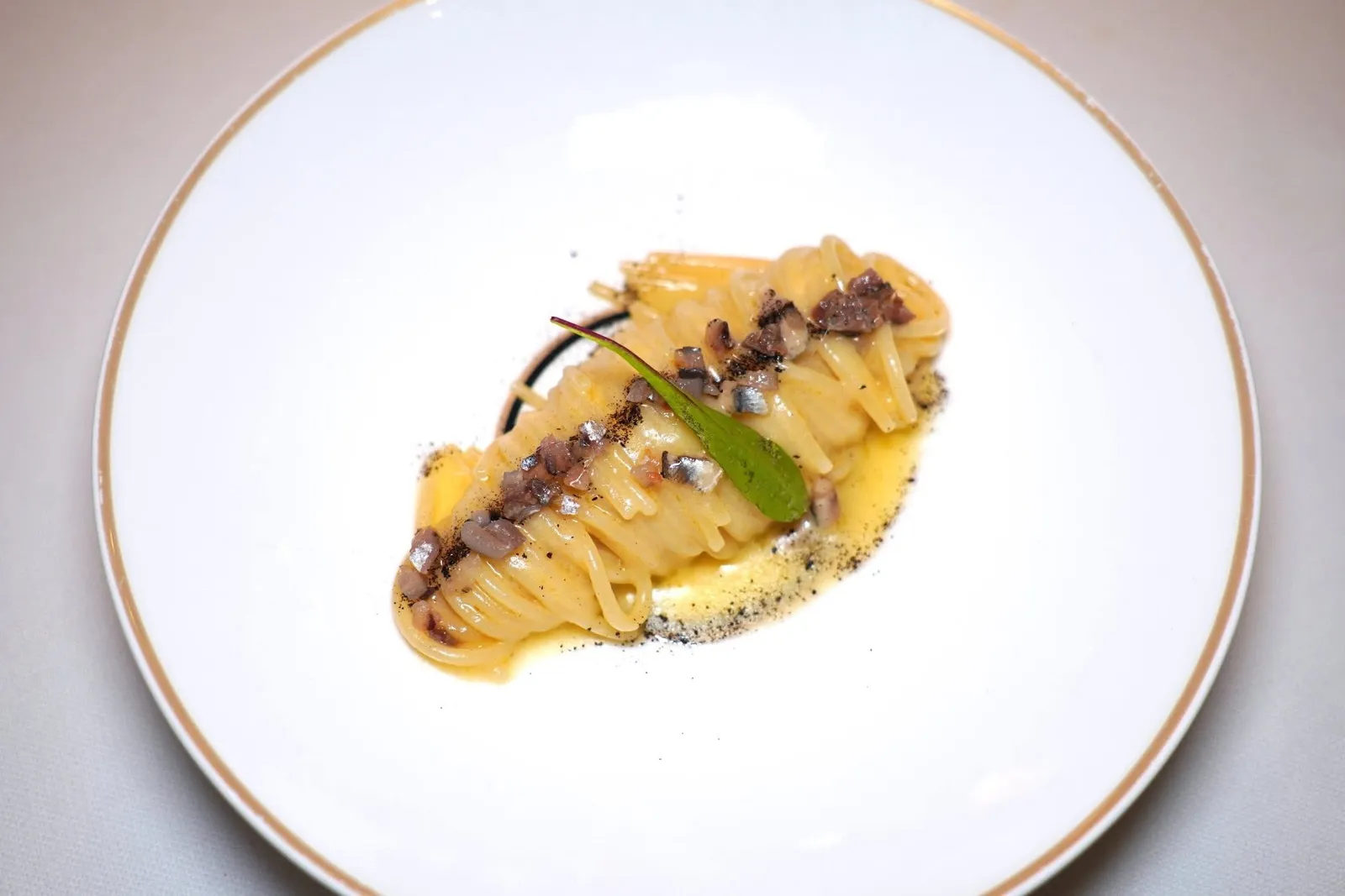 SPAGHETTI CREAMED WITH BUTTER, ANCHOVIES AND SMOKED TEAพาสต้าเส้น Spaghetti เกรดพรีเมี่ยมแบรนด์ Mancini เสิร์ฟมาที่ความสุก Al Dente ไร้ที่ติ เชฟคลุกเคล้ากับซอสเนยหอมมันและปลาแอนโชวี่จากเมือง Cetara ในแคว้น Campania ให้รสเค็มอูมามิที่พอเหมาะ นอกจากนี้ยังมีอโรมาของผงที่เตรียมมาจากชาดำรมควัน Lapsang Souchong ของจีนบ่งบอกถึงการเดินทางของเชฟมายังทวีปเอเชียอีกด้วย (18/20)