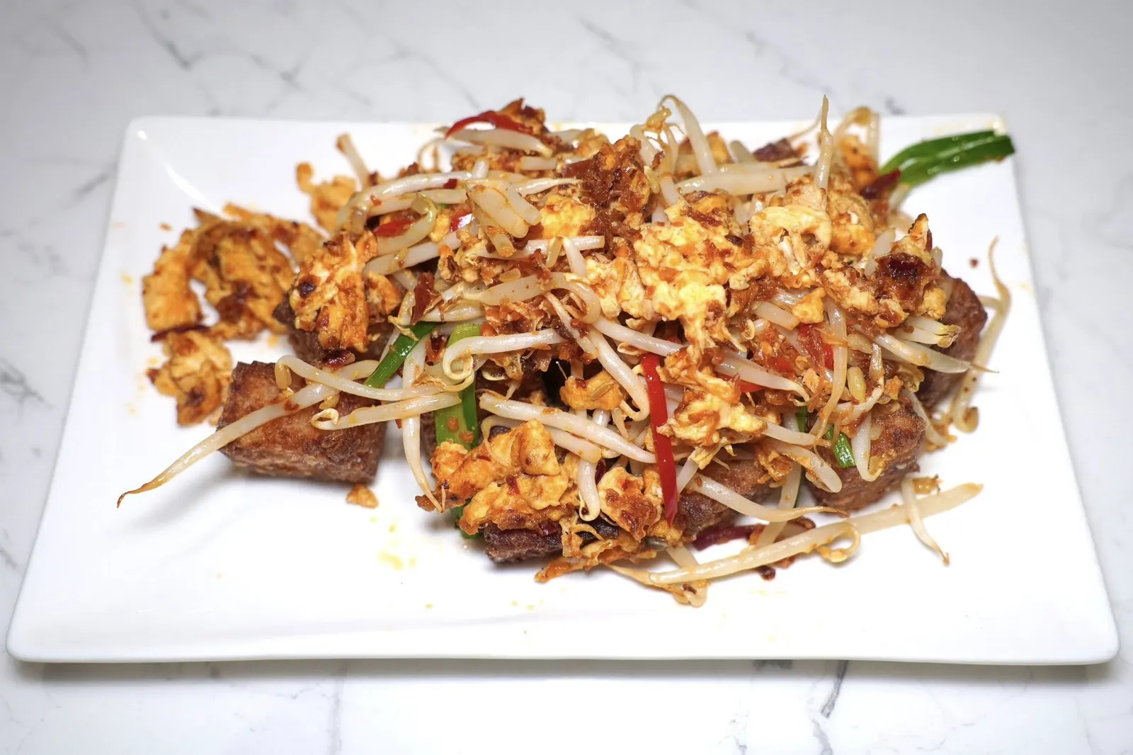 ขนมผักกาดผัดซอส X.O.Stir Fried Radish Cake with X.O. Sauceขนมผักกาดจานใหญ่คลุกเคล้ากับซอสเอ็กซ์โอรสชาติจัดจ้าน นอกจากนี้ยังมีกลิ่นหอมของไข่และความกรอบที่ได้จากถั่วงอกอีกด้วย