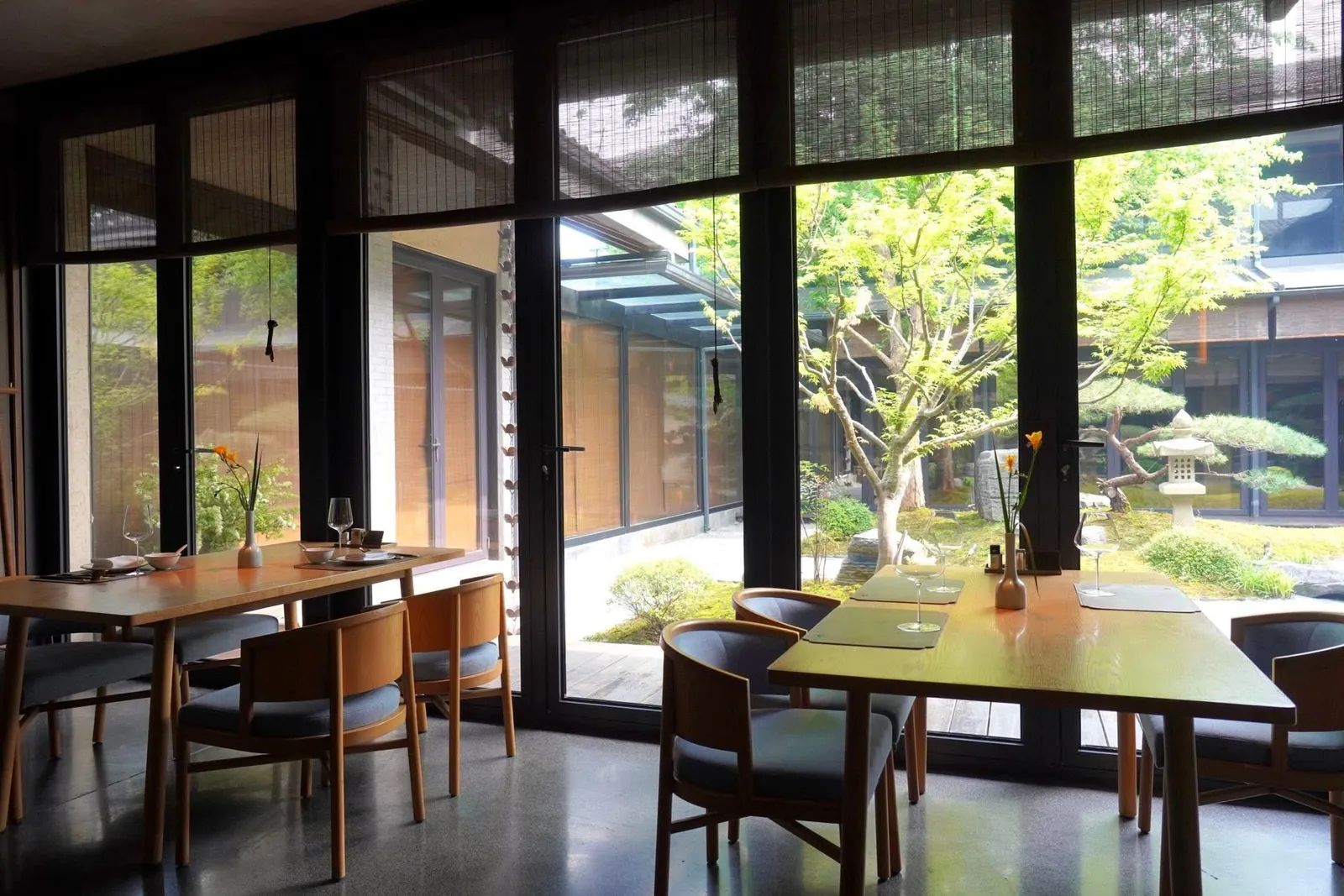 ห้องรับประทานอาหารหลักตรงแต่งด้วยโทนสีเข้มมองออกไปเห็นวิวสวน
