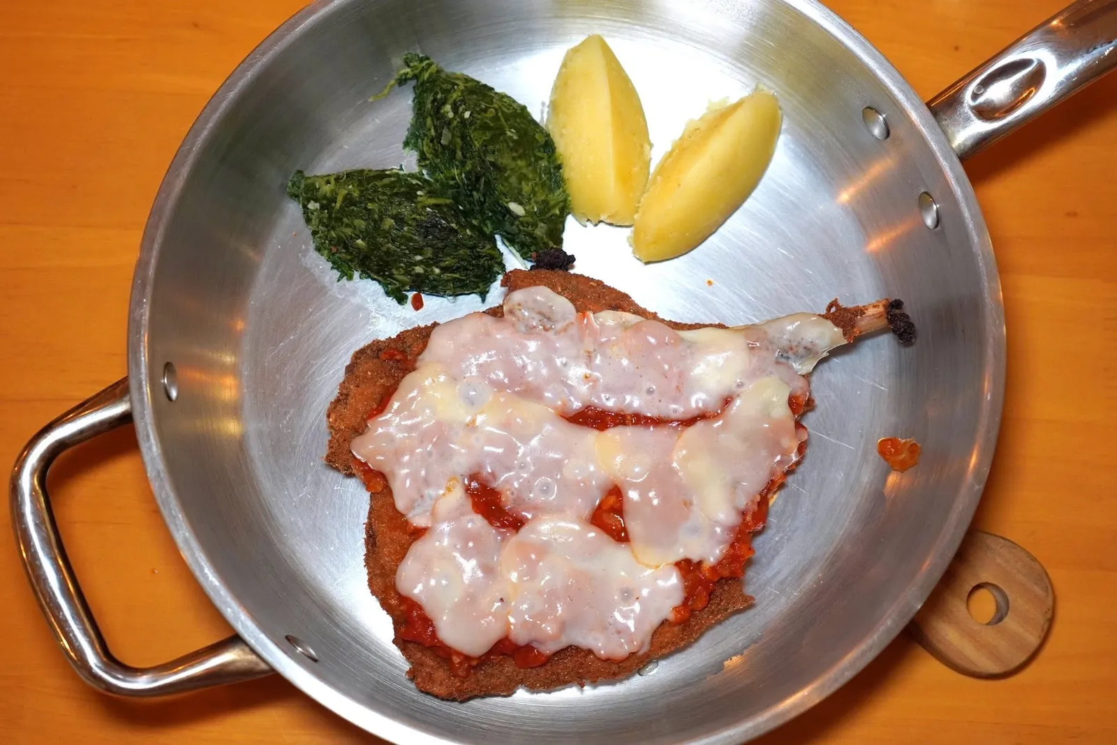 COSTOLETA MILANESE DI MANZO ALLA PARMIGIANA (960+)Milanese Veal Cutlet With Tomatoes & Cheeseเนื้อลูกวัวชิ้นโตที่ผ่านการชุบเกล็ดขนมปังทอดกรอบ จากนั้นราดด้วยซอสมะเขือเทศและชีสแล้วเสิร์ฟมาในกระทะเหล็ก ข้าง ๆ กันยังมีผักปวยเล้งและมันบด (14/20)