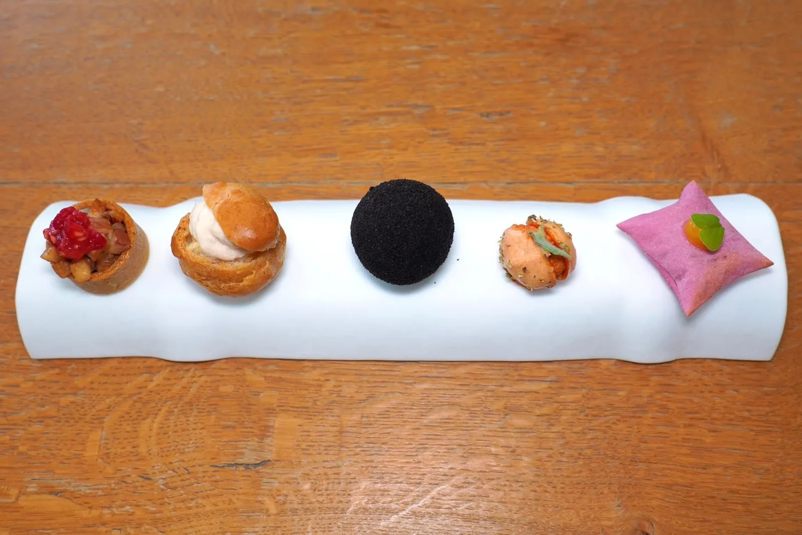 CHEF’S WELCOMEของว่างเรียกน้ำย่อยเรียงจากฝั่งขวาไปซ้ายคือแป้งทรง Air Bag กรอบ ๆ ด้านในบรรจุชีส Stracchino ด้านบนท็อปด้วย Tangerine Gel และใบ Sorrel ถัดมาคือ Tomato Meringue หรือเมอแรงก์มะเขือเทศรสเปรี้ยวเบา ๆ จับคู่มากับชีส Caprino และออริกาโน ชิ้นที่สามคือ Fried Croqueta กรอบ ๆ จับคู่กับเห็ด Porchini และ Cardoncelli ส่วนชิ้นที่สี่คือ Choux และมูสที่เตรียมมาจากแฮมจากเมือง Norcia สุดท้ายคือ Tartelette ที่ผสมผสานรสชาติของหัวหอม ปลาไหล และราสเบอร์รี่เข้าด้วยกัน (14/20)