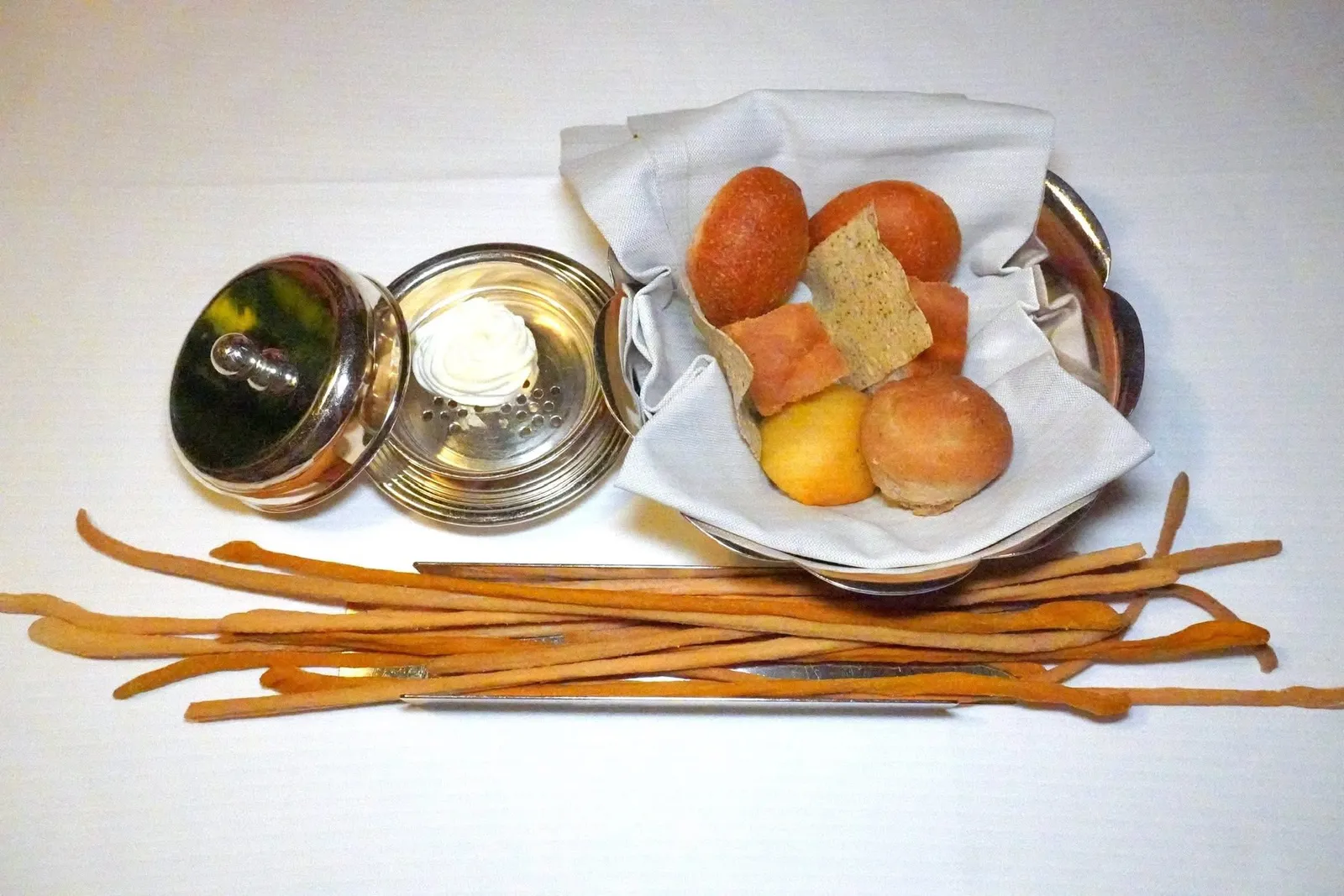 Bread and Butterขนมปังเสิร์ฟมากับเนย Sour Cream Butter ถัดมาคือ Grissini โฮมเมดสีเหลืองเตรียมมาจากพืชตระกูล Curcuma ส่วนสีเข้มคือ Schüttelbrot ยังมี White Bread ที่มีส่วนผสมของมันฝรั่งกับชีส และ Dark Bread รวมไปถึง Olive Focaccia อีกด้วย