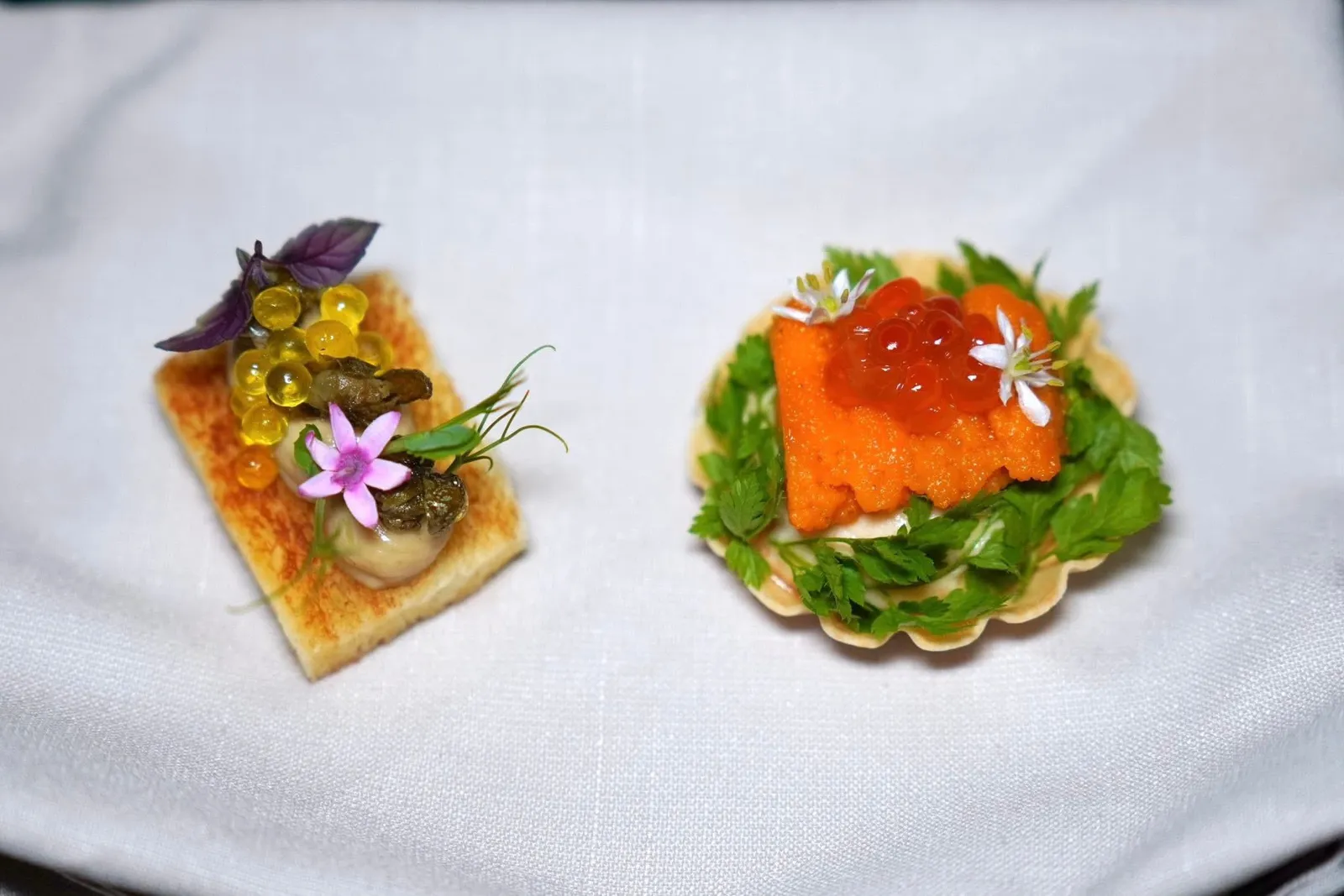 🥄 AMUSE-BOUCHEFrench Brioche with Foie Gras Mousse, Caperเริ่มต้นด้วยขนมปัง Toast ท็อปด้านบนด้วยมูสฟัวกราส์หอมมัน มีอโรมาของเคเปอร์ทอด และ Caviaroli หรือน้ำมันมะกอกคาเวียร์Uni Tart with Salmon Roe Saladอีกฝั่งหนึ่งคือมินิทาร์ตขนาดจิ๋ว ด้านในเป็นเนื้อปลาแซลมอนเตรียมมาคล้ายกันกับมูส จากนั้นท็อปด้วยใบเชอร์วิล อูนิ และไข่ปลาแซลมอน