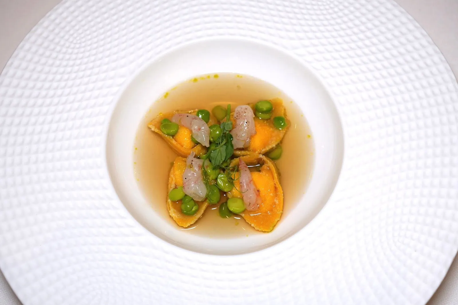 Curdled goat's milk ravioli, pea and ham water, Mediterranean pink shrimpsราวิโอลีชิ้นจิ๋วที่บรรจุนมแพะที่ทำให้จับตัวกันเป็นก้อนให้เนื้อสัมผัสแบบ Milky ในถ้วยยังมีกุ้งชมพูจากทะเลเมดิเตอร์เรเนียนและถั่ว Green Pea ให้ระดับความหวานและรสชาติที่แตกต่างกัน จากนั้นพนักงานน้ำซุปใสที่เตรียมมาจากแฮม Proscuitto และถั่ว Green Pea ลงไป พนักงานแนะนำให้ชิมเฉพาะชิ้น Ravioli เปล่า ๆ ก่อนจะจับคู่กับองค์ประกอบอื่น ๆ ในถ้วย (16/20)