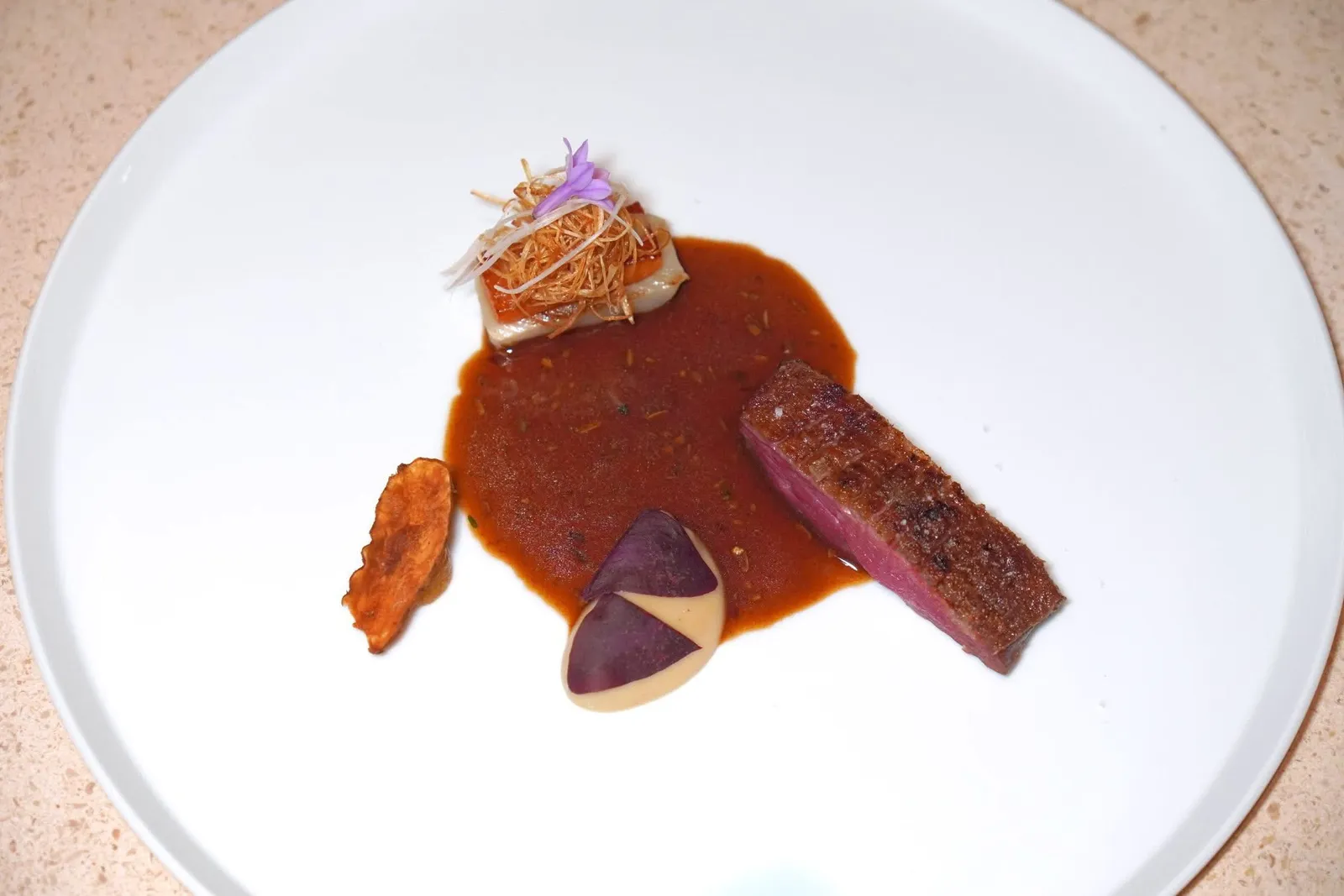 Duckjerusalem artichoke, leek, persimmon, gingerเนื้อเป็ด Barbary ที่ผ่านการ Dry-aged เสิร์ฟมากับแก่นตะวัน กระเทียมต้น และลูกพลับ จากนั้นจึงเทราดซอสที่ผสมผสานเมล็ดเฟลเนลและลูกพลับผสมผสานให้รสชาติที่หลากหลายและมีมิติ (14/20)